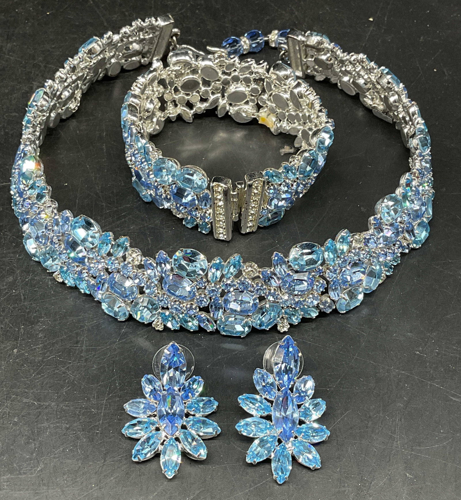 Set 3 Vintage Napier Blue Rhinestone Jewelry: Set of 3 vintage matching Napier silver tone and blue rhinestone jewelry. 1 Collar necklace, 1 bracelet, and 1 pair of earrings. Necklace measures approx. 5 inches wide. Bracelet measures approx. 2.25