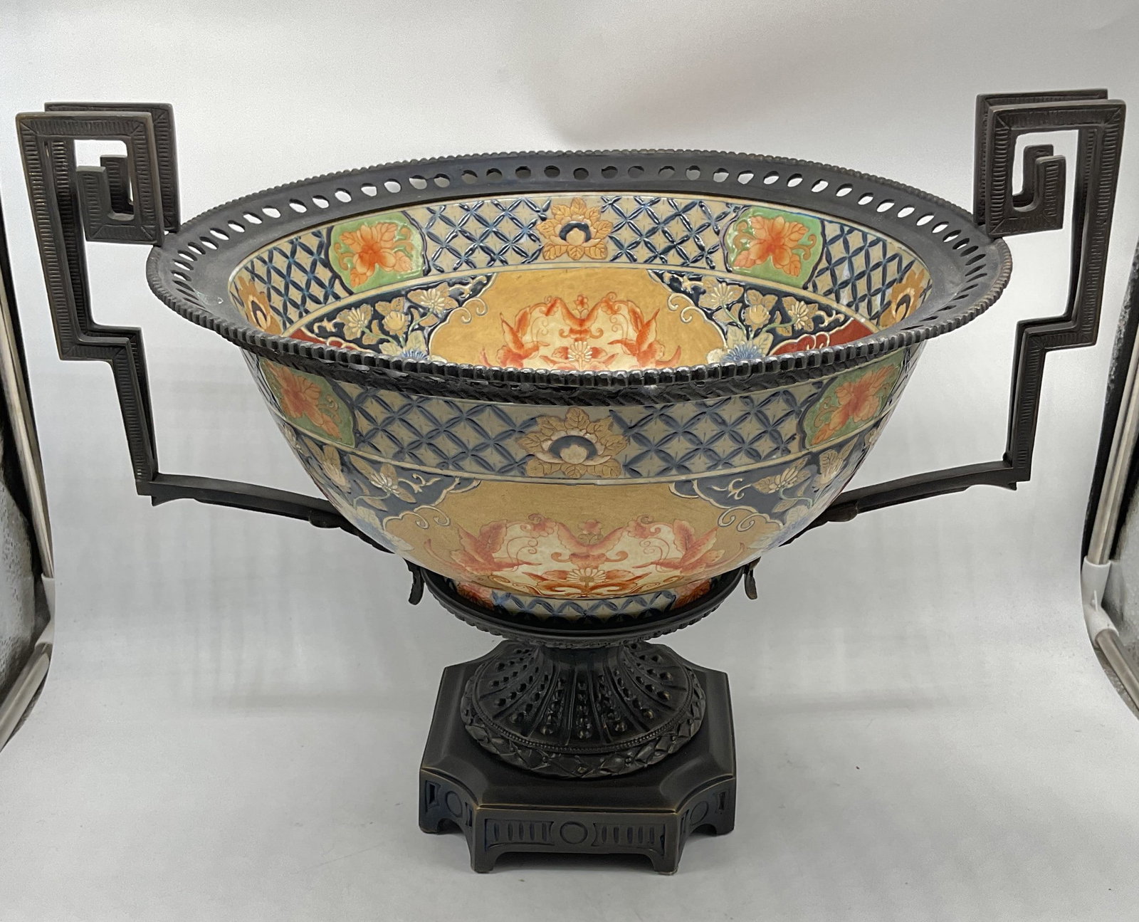 Maitland Smith Imari Enamel Pedestal Bowl: Maitland Smith Imari style centerpiece bowl. Pedestal bowl with decorative handles. Hand painted enamel over metal with bronze base. Measures approx. 17.25 x 14 x 13.25 inches. Some scratching and pat