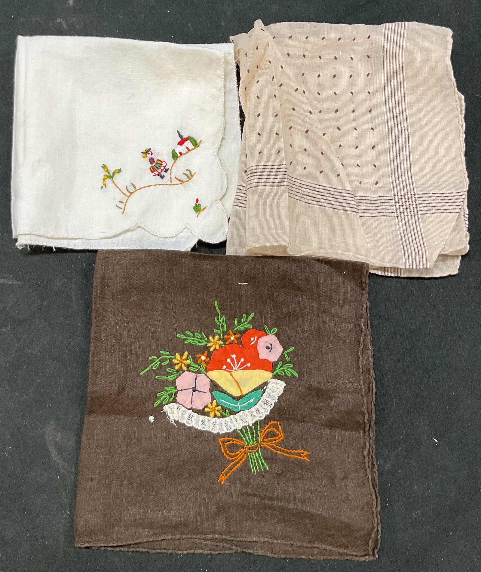 Lot 3 Assorted Linen Cocktail Napkins: Lot of 3 assorted linen cocktail napkins. White, brown, cream. Embroidered floral and figural motifs in varying colors. Geometric pattern. Scalloped trim. Measures approx 10 x 10 inches. Blemishes. Co