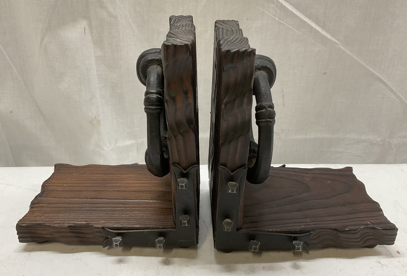 VTG Brutalist-Style Wood&Iron Bookends SPAIN: Vintage Brutalist-Style Carved Dark Wood and Wrought Iron Bookends. Two Rings and Studded Accents. Made in Spain. Some Scratching. Measures app 7in H x 6in L x 3.75in W. Vintage, Brutalist-Style, Spai