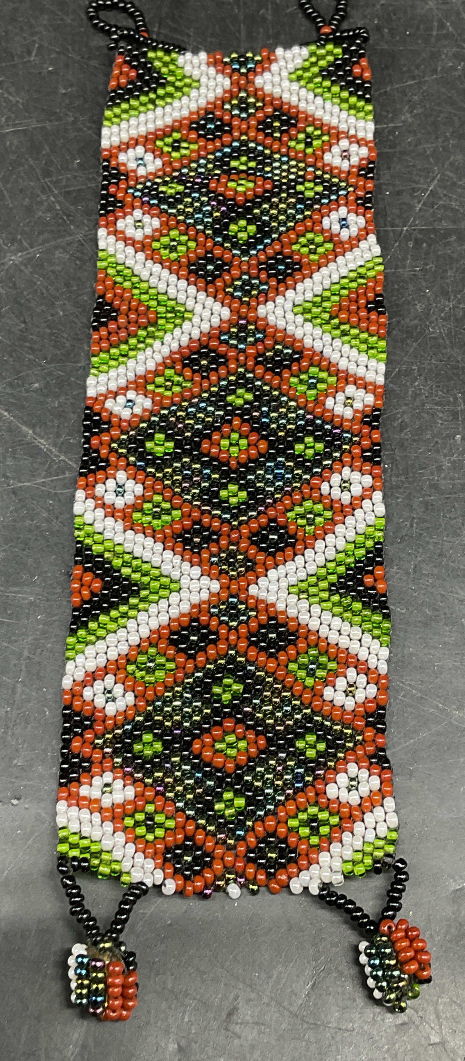 Hand Beaded Green Brown Geometric Bracelet: Hand beaded green and brown geometric bracelet. Measures approx. 6.5 inches long, 2 inches wide. Some scratching. Jewelry, estate jewelry, costume jewelry, cocktail jewelry, fashion jewelry, accessori