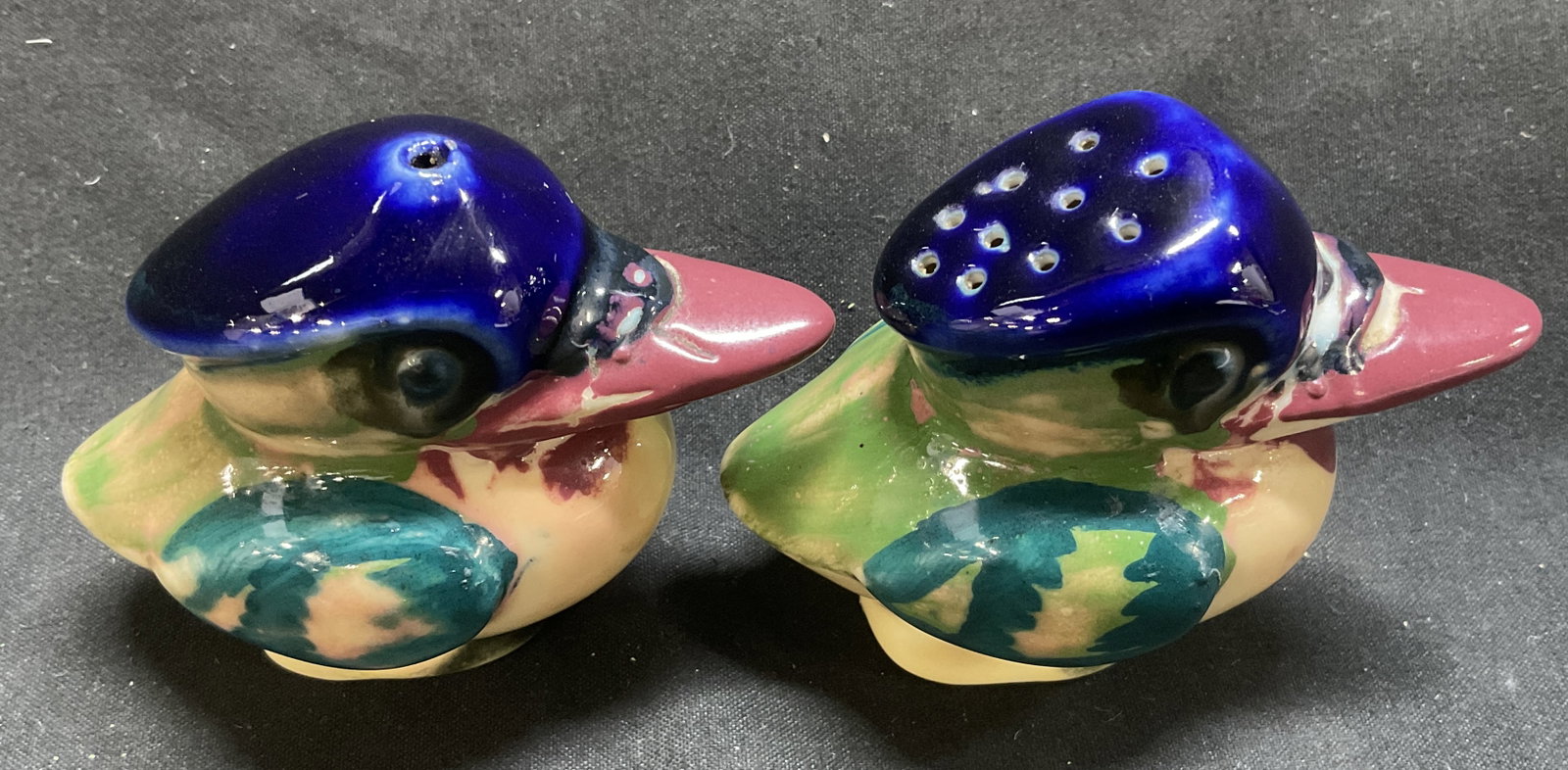 VTG 50s Kookaburra Earthenware Salt&Pepper Shakers: Vintage 1950s Kookaburra Earthenware Salt and Pepper Shakers. Cobalt Blue Heads with Yellow, Green, and Red Bodies. Some Color Loss. One Cork Stuck Inside. Measures app 2.5in H x 3in L. Vintage Kitche