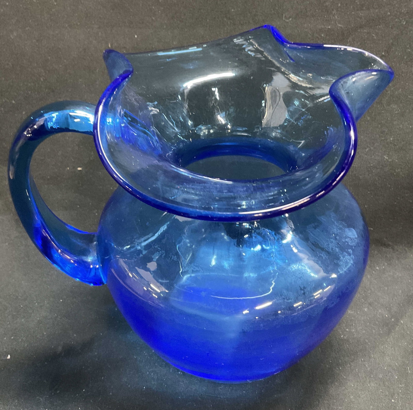 MCM Hand-Blown Ruffled Blue Art Glass Pitcher: Mid-Century Modern Hand-Blown Ruffled Blue Art Glass Pitcher. Condition Consistent With Exposure. Measures app 6in H x 6.5in Diam. Mid-Century Modern, Hand-Blown, Ruffled, Blue Glass, Art Glass,