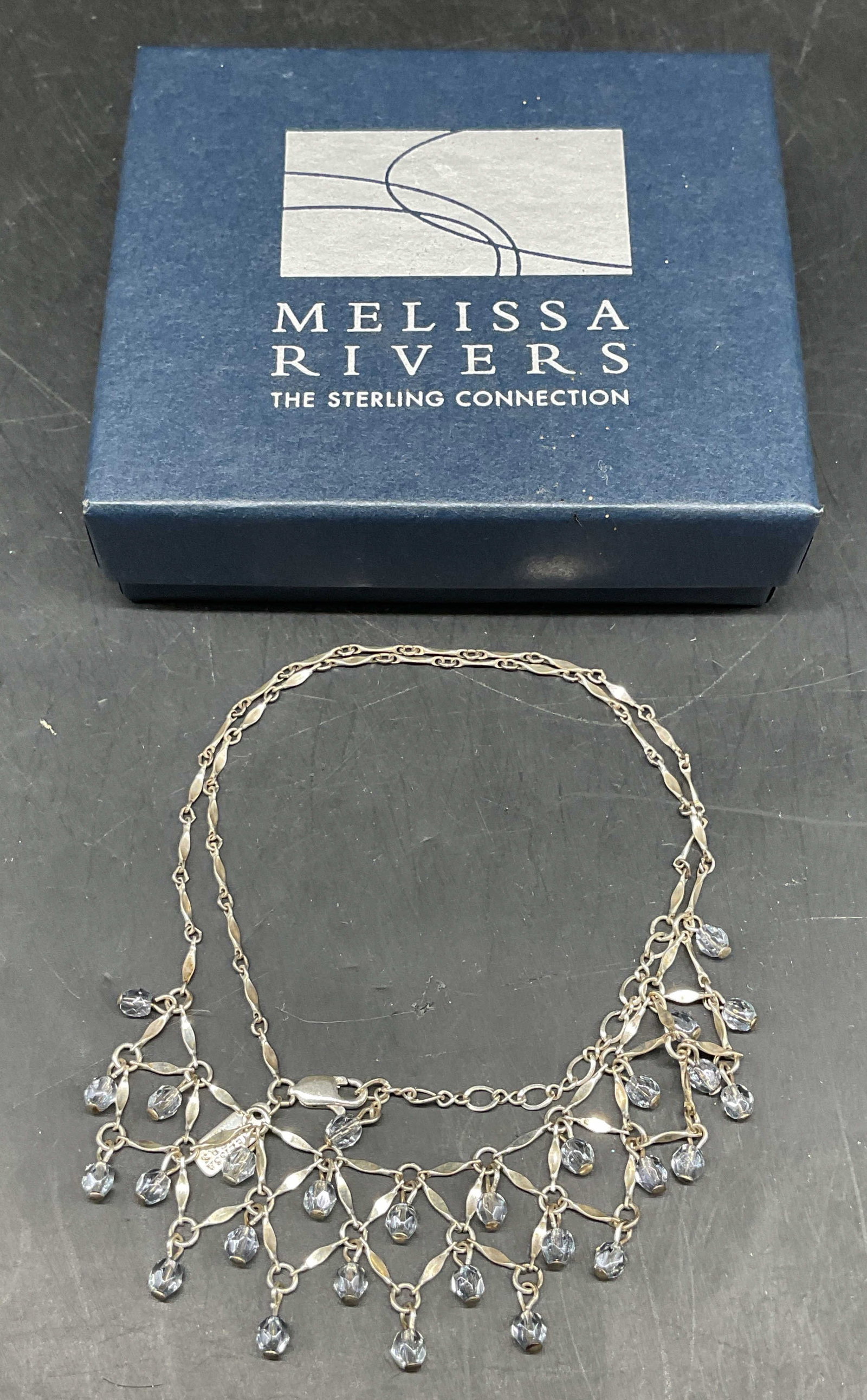 Melissa Rivers Sterling Silver Crystal Necklace: Melissa Rivers sterling silver necklace with blue crystals. Drop length 8.75 inches. Marked sterling. Total weight 9.7 grams. Includes box and jewelry pouch. Some scratching. Jewelry, estate jewelry, 