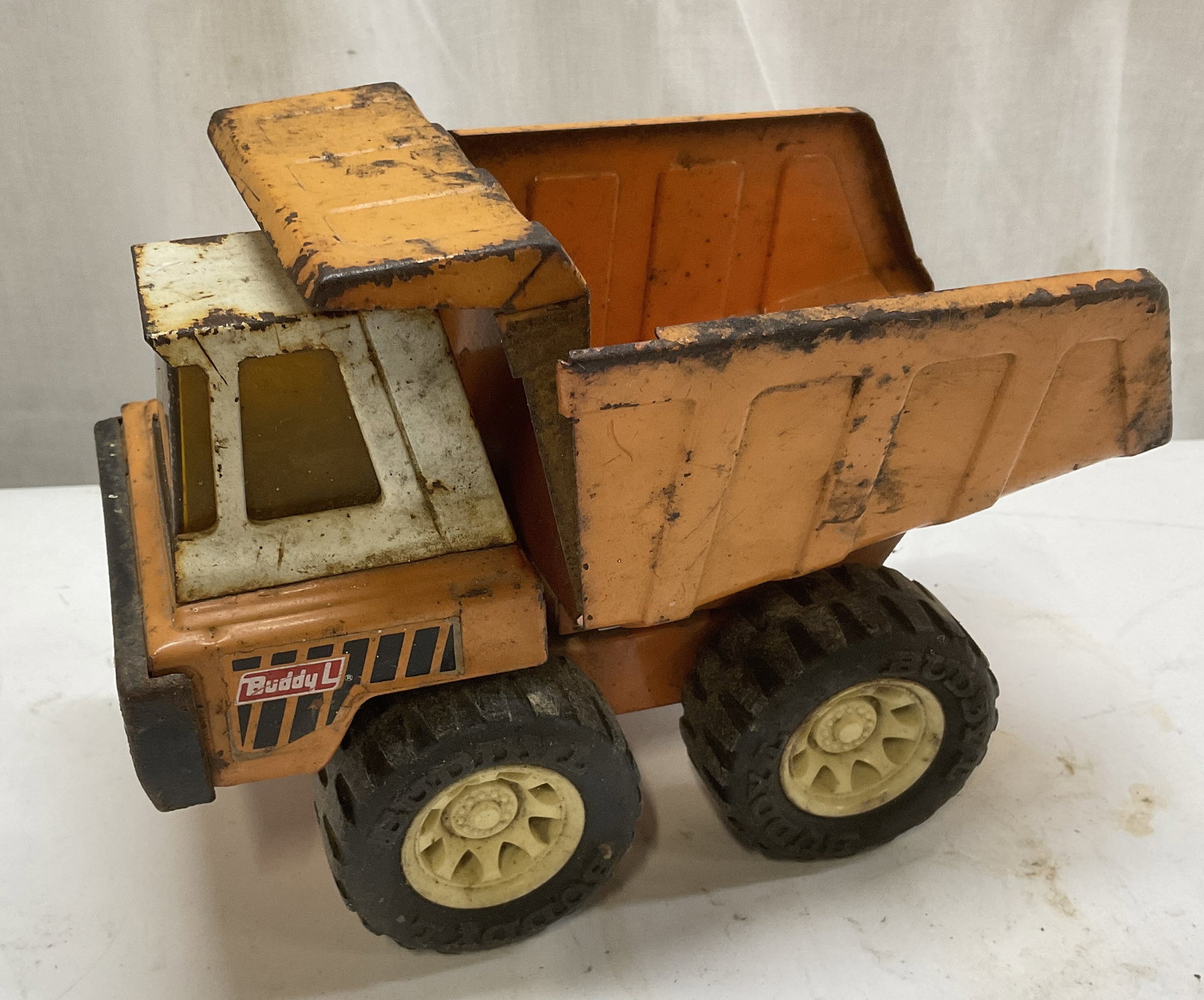 70s Buddy L Steel Hydraulic Dump Truck JAPAN: Vintage 1970s Buddy L Orange Pressed Steel Hydraulic Dump Truck Toy. Made in Japan. Aging to Metal and Cracks Present. Needs Adjustment. Measures app 6in H x 8in L. Vintage Toys, 1970s, Buddy L, Orang