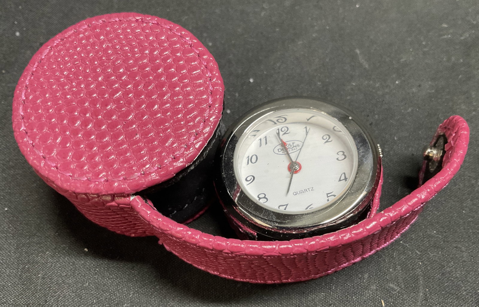 VTG Wolf Designs Alarm Clock Pink Leather Case: Vintage Circa 1990s-2000s Wolf Designs Pop-Up Silver-Toned Metal Travel Alarm Clock in Pink Pebbled Leather Circular Case. Snap Reads Leather. Clock has Battery-Operated Quartz Movement. Reads Wolf De
