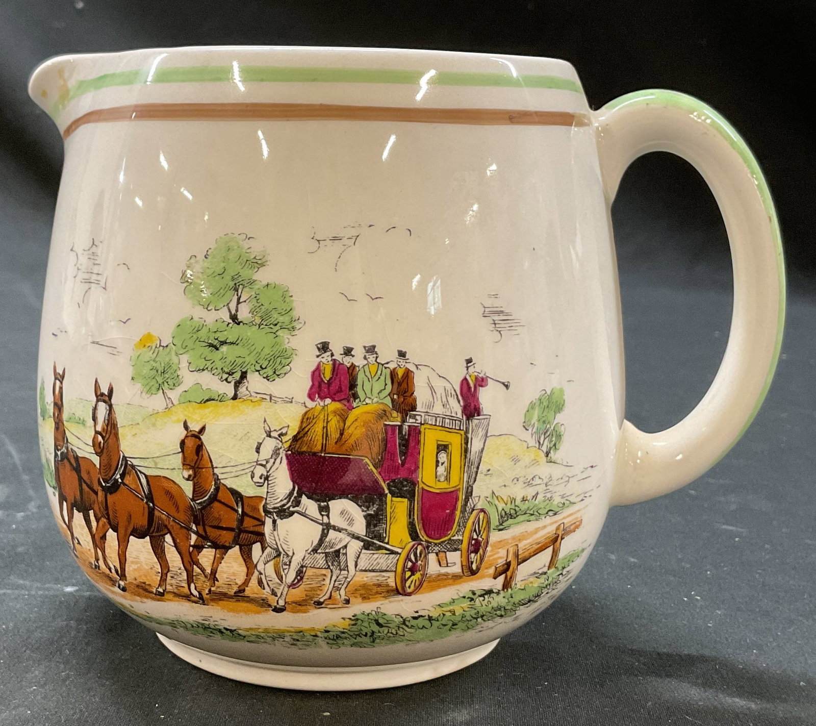 Portland Pottery Bygone Days Creamer England: Portland Pottery Bygone Days ceramic creamer. Marked on underside, made in England. Bygone Days coaching scene, figure horses and tree motifs. Varying colors. Measures ht approx 4.5 inches diam approx