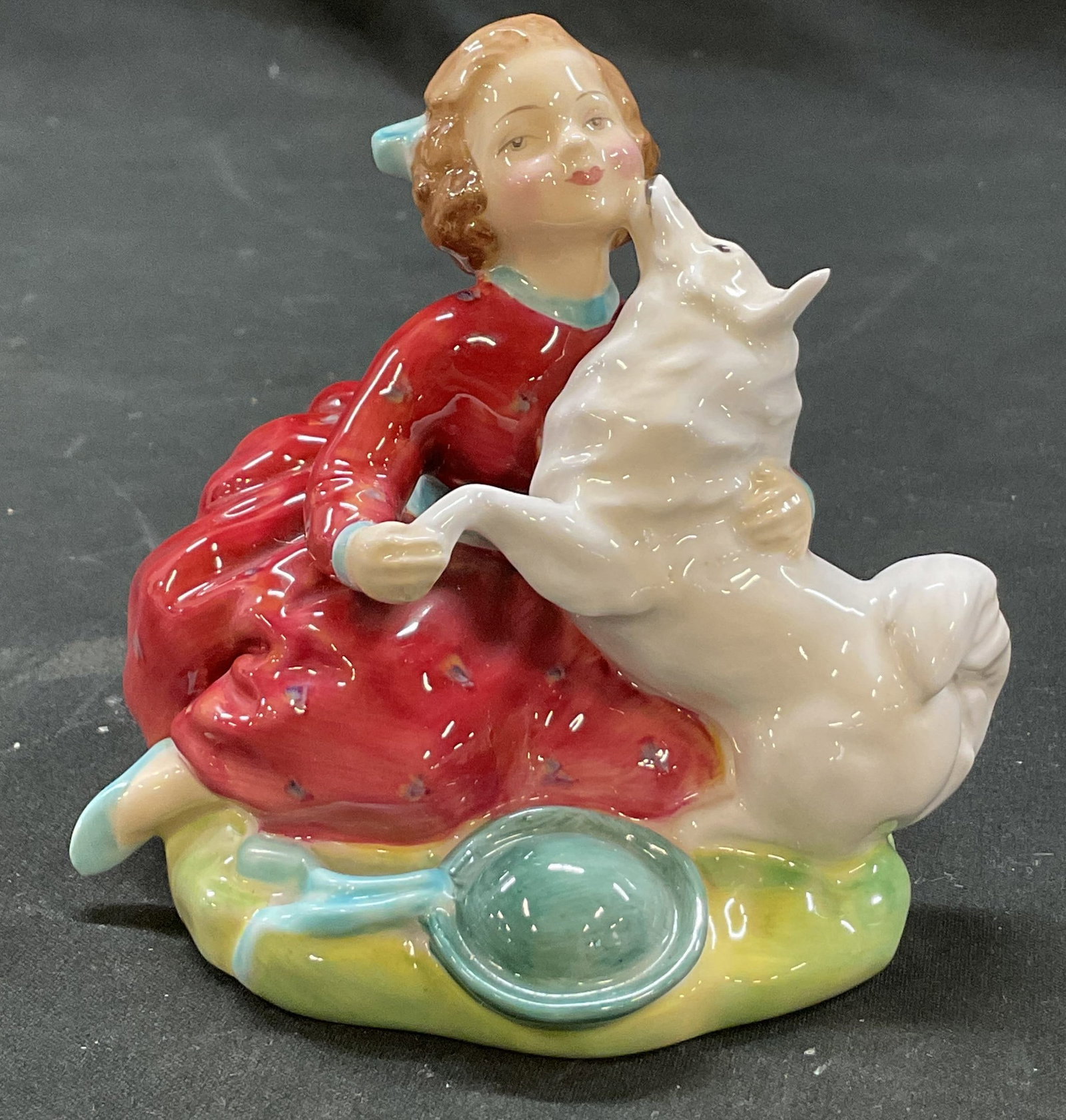 Royal Doulton Home Again Figure England: Royal Doulton Home Again bone china figure. Marked on underside, reads Made In England Royal Doulton Bone China Home Again. Sitting figure with white dog. Hand painted in varying colors and glossy fin