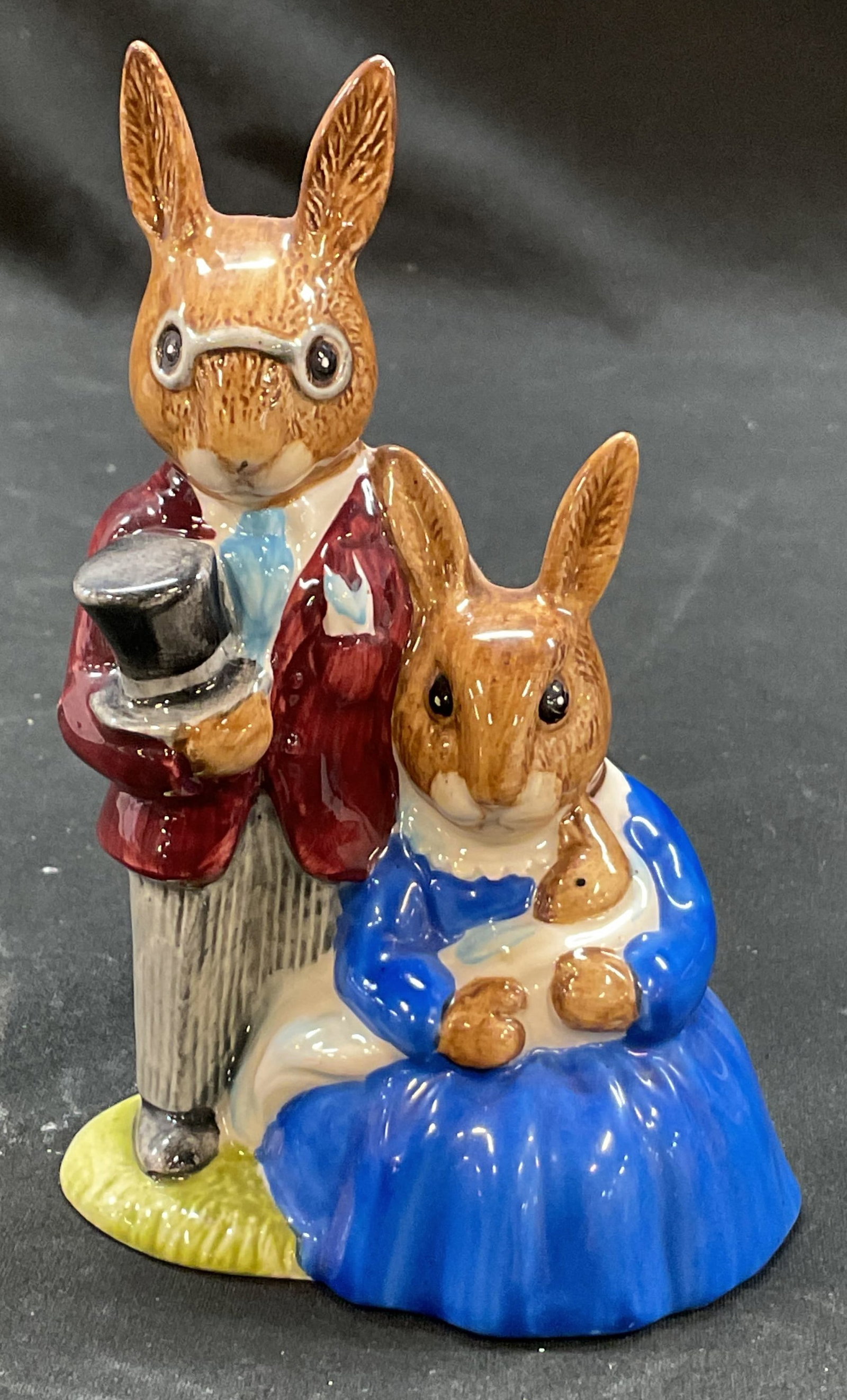 1972 Royal Doulton Bunnykins Family Figure England: Royal Doulton bone china Bunnykins Family Photograph figure. Marked on underside. Made in England, 1972. Two bunny figures, one is holding a baby bunny. Hand painted in varying colors, glossy finish. 