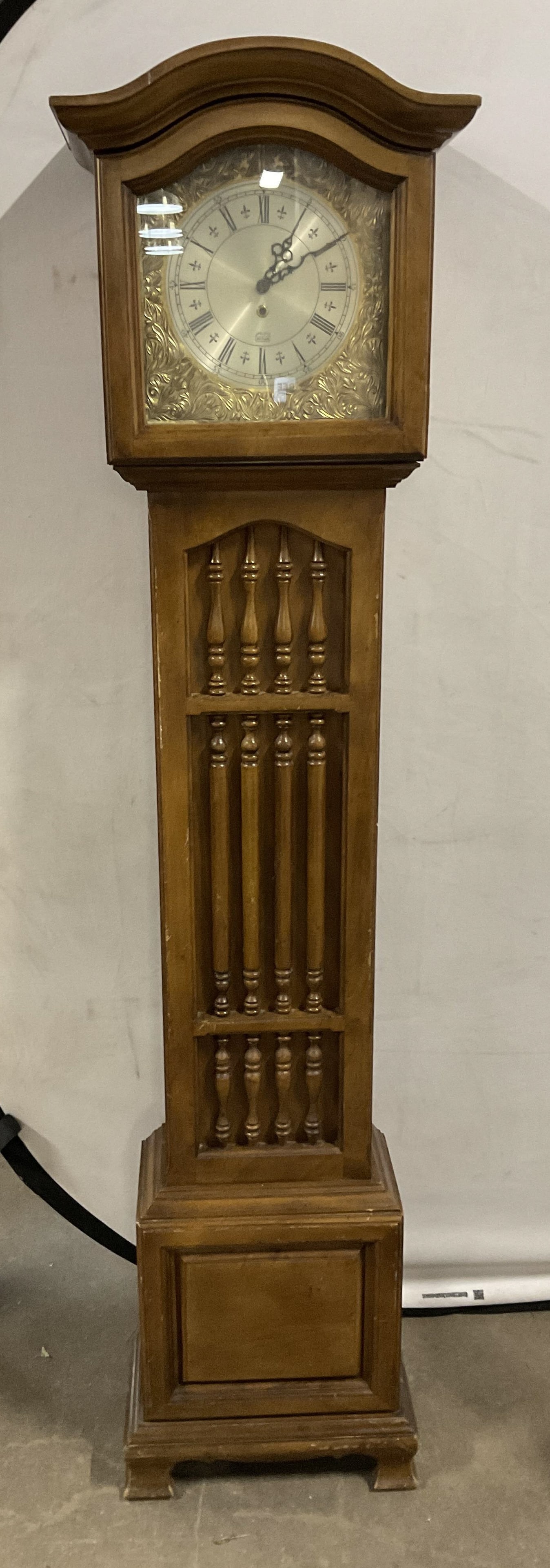 VTG Butler Specialty Co 66.5in Grandfather Clock: Vintage Butler Specialty Company Wooden Grandfather Clock. Gold-Toned Metal with Floral Design Surrounding Clock Face. Scratching and Scuffing Present. Not Tested for Functionality. Measures app 66.5i