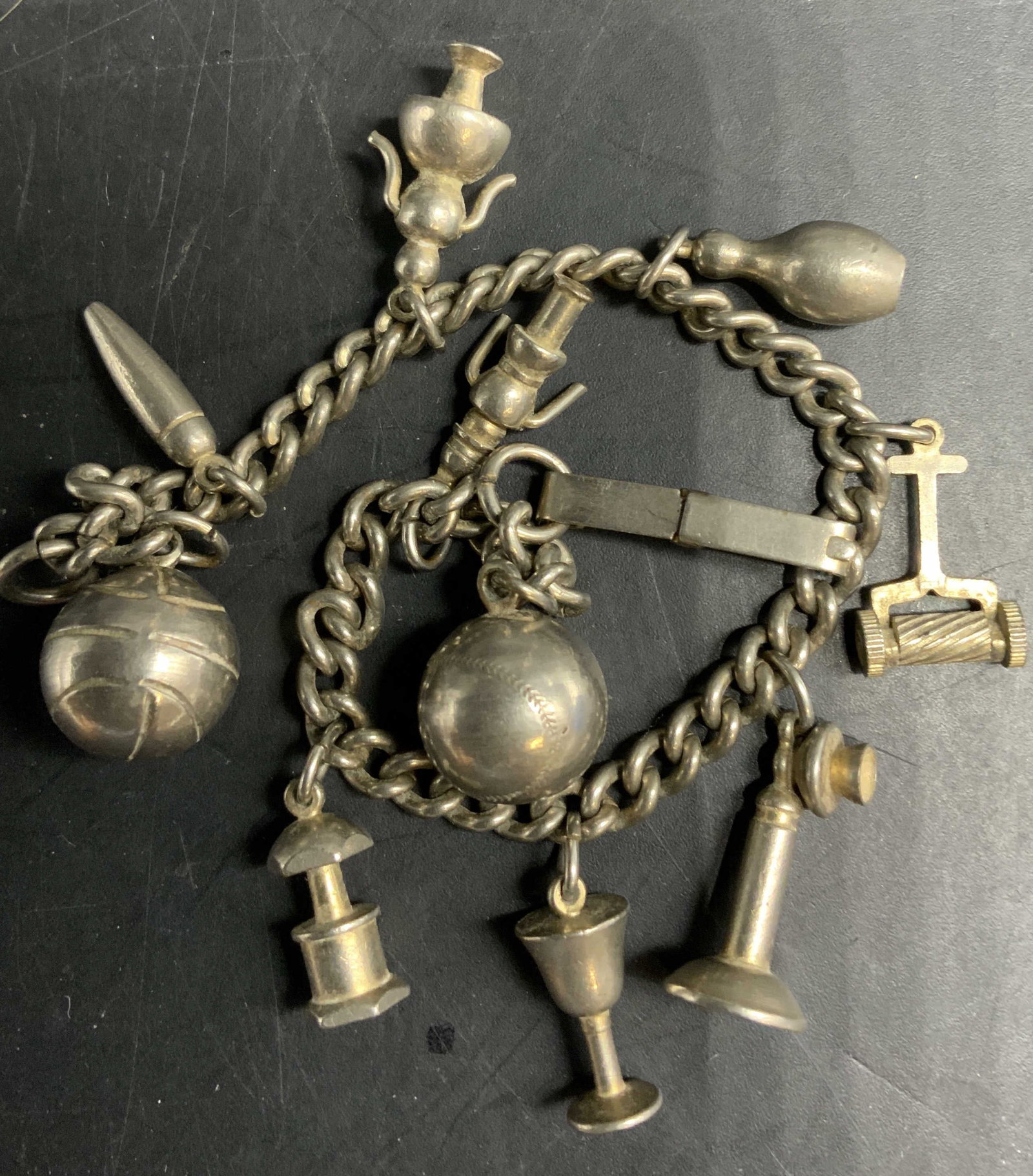 Silver Toned Chunky Charm Bracelet , Vntg: Vintage Silver toned Chunky charm bracelet, charms include, basket ball, baseball, telephone, bowling pin. Chalice, girl figural, and more, length app 8 inches estate jewelry, costume jewelry, fashion
