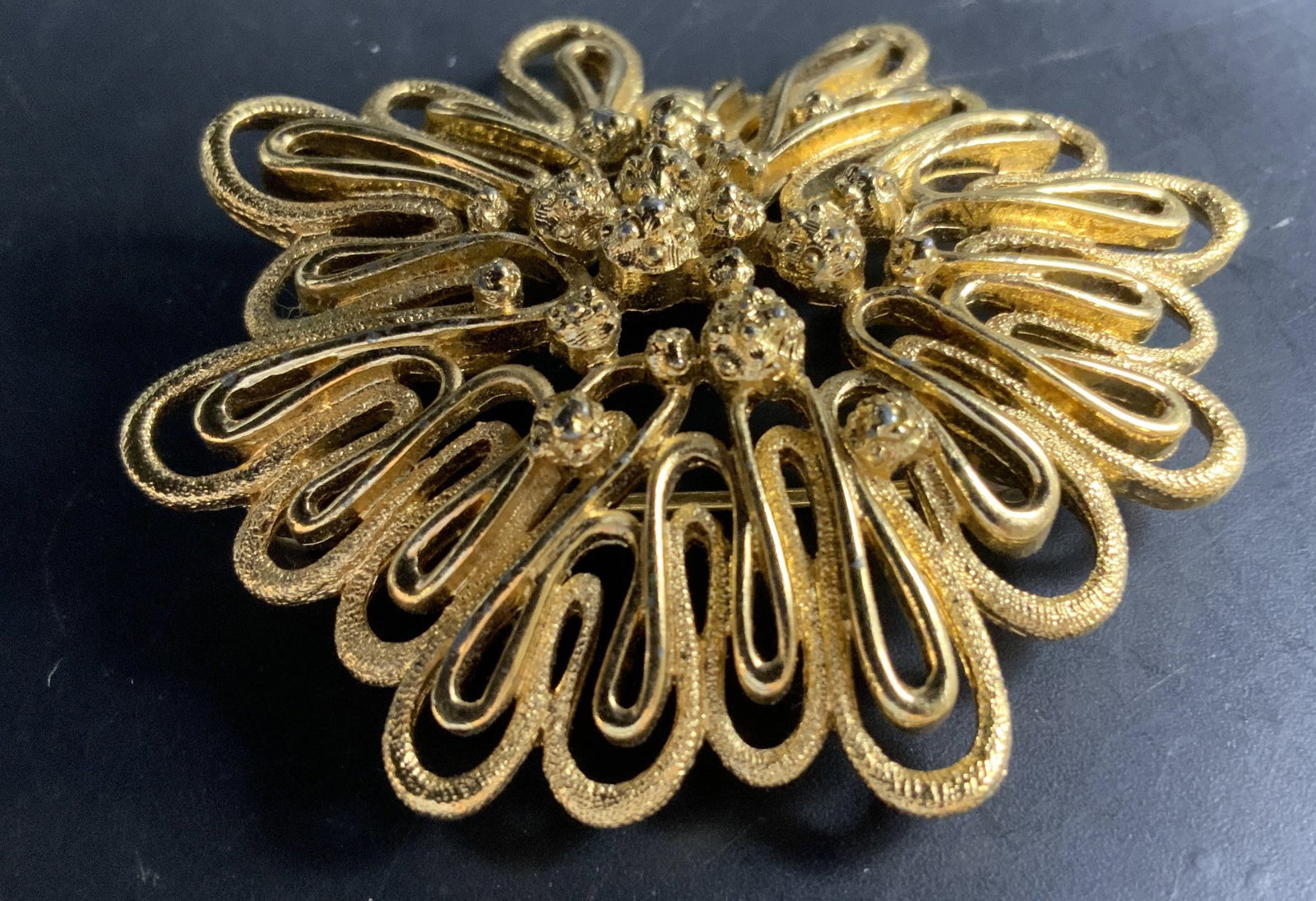 Vintage MONET gold Toned Palazzo Brooch, 1968: Vintage Monet Palazzo Brooch from 1968 features a gold tone filigree flower design with a textured layered center diameter app 2 inches