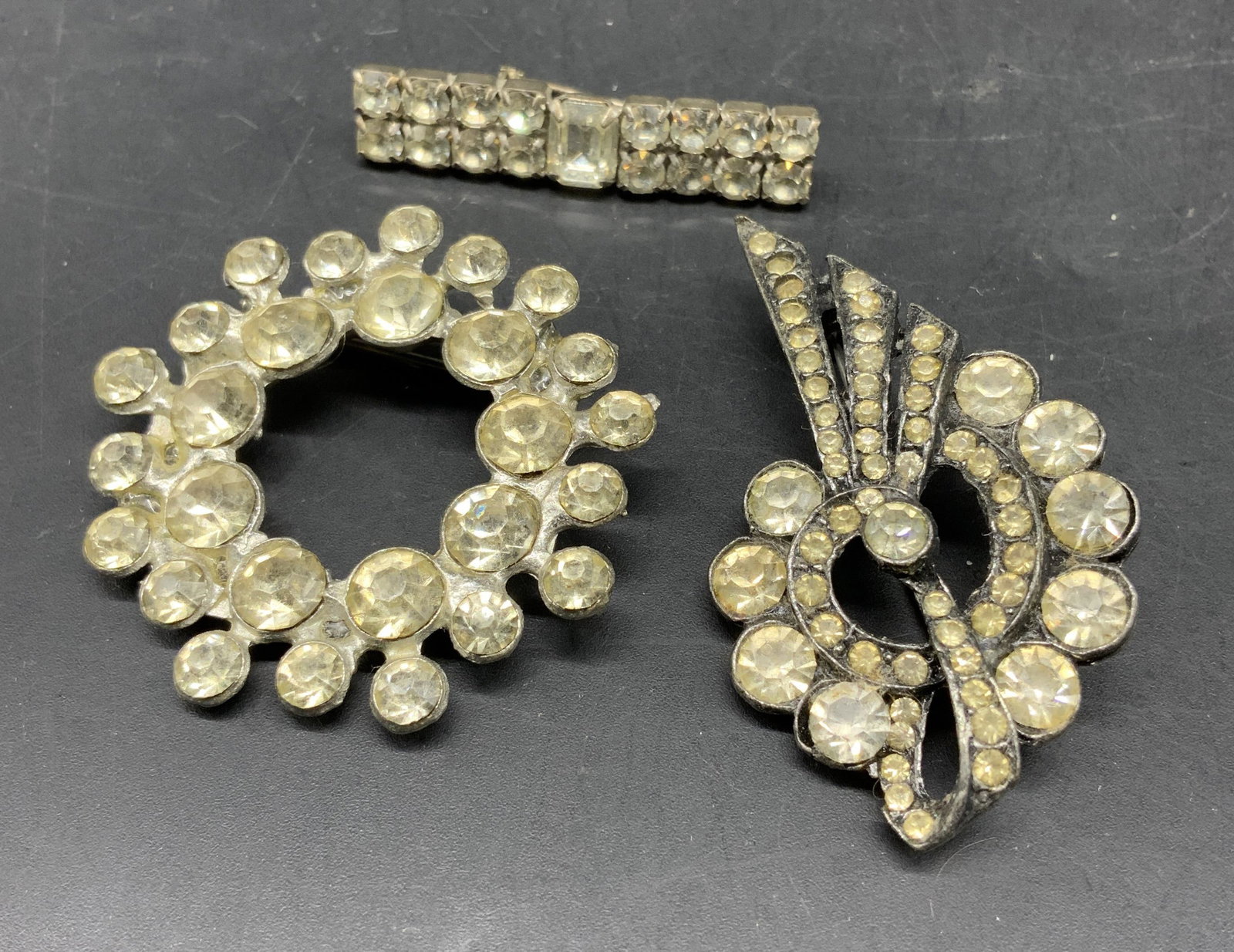 Group 3 Art Deco Rhinestone Brooches: Vintage art deco rhinestone stone brooches, pins, one is a double bar design, one is triple ring design, and one is a swirl and spray design, largest measures 2 inches, fashion jewelry, estate jewelry