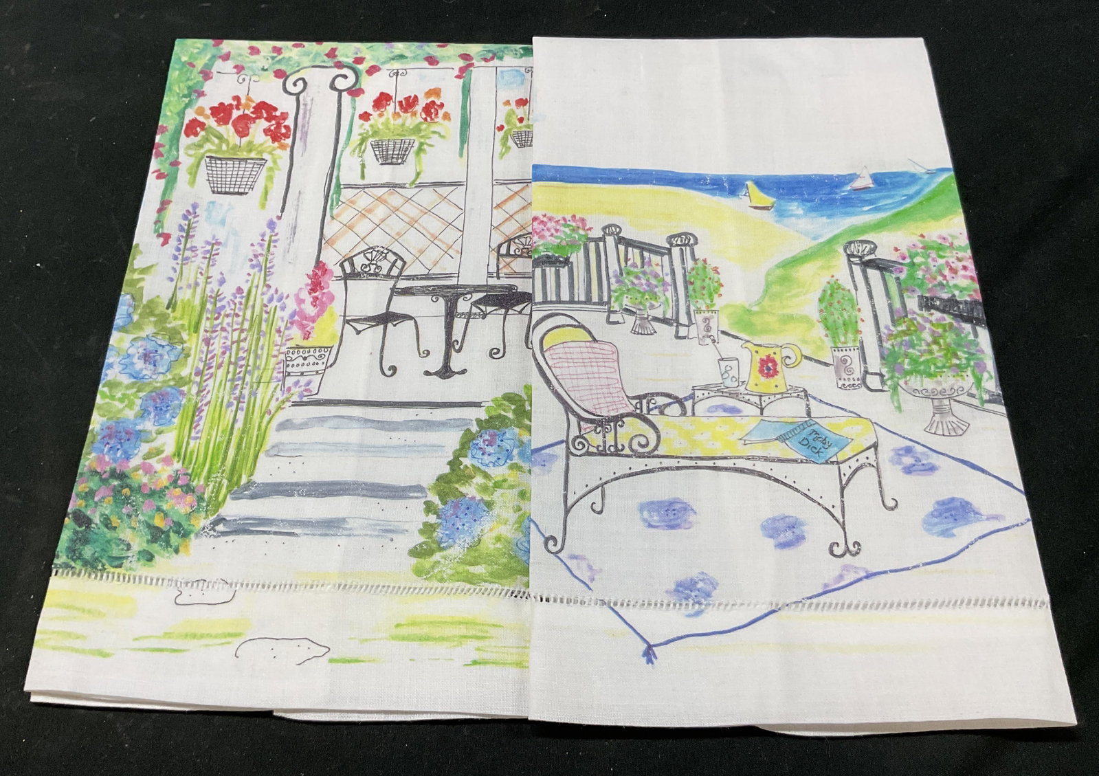 Lot 2 Cynthia Hulbert Linen Tea Towels USA: Lot of 2 Cynthia Hulbert linen tea towels. Marked on surface, hand embellished in USA. Hand painted landscape scenes of water, boats, chairs, tables, flowers, and more. Varying colors. Measures approx