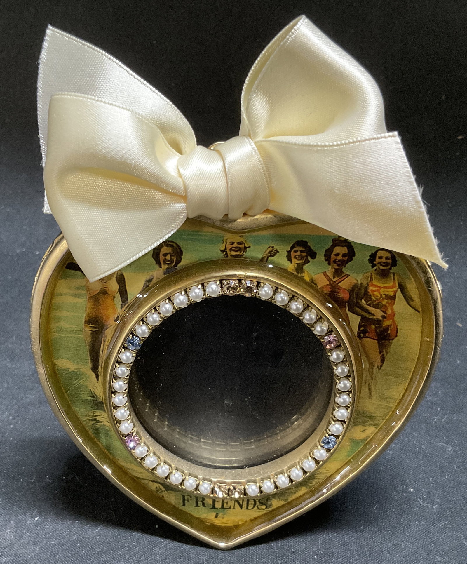 VINTAGE Maximal Art Friends Picture Frame: Vintage Maximal Art Friends Heart-Shaped Picture Frame. Gilt Metal Trim with Vintage-Style Enamel Graphics of Women at the Beach. Rhinestone and Beaded Circular Border. Bow Accent. Some Staining on Ba