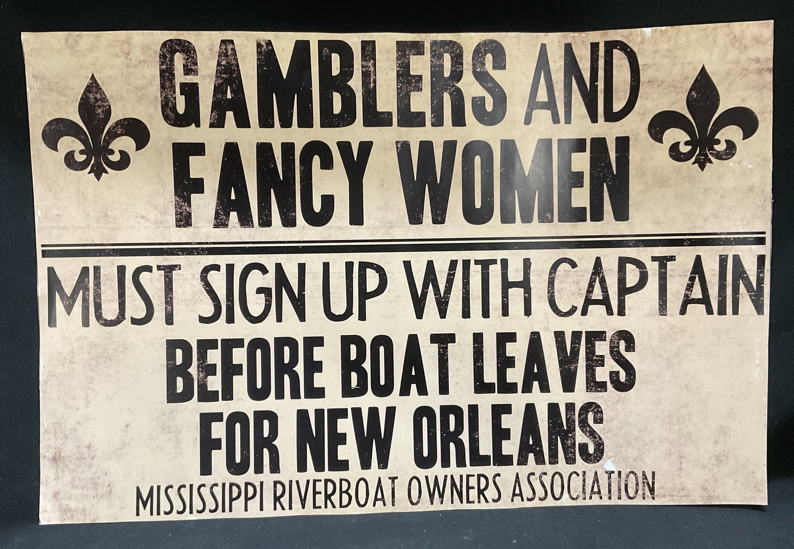 VTG-Style Mississippi Riverboat Poster: Vintage-Style Mississippi Riverboat Poster. Beige Weathered Style Background. Fleur-De-Lis Icons. Text Reads Gamblers and Fancy Women Must Sign Up With Captain Before Boat Leaves for New Orleans. Miss