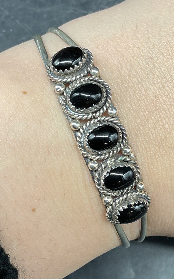 Nakai Navajo Sterling Silver Semiprecious Bracelet: Signed Gilo & Grace Nakai sterling silver cuff bracelet with black semiprecious cabochons. Measures approx. 2.25 inches wide. Total weight 9.9 grams. Marked sterling. Some scratching. Jewelry, estate 