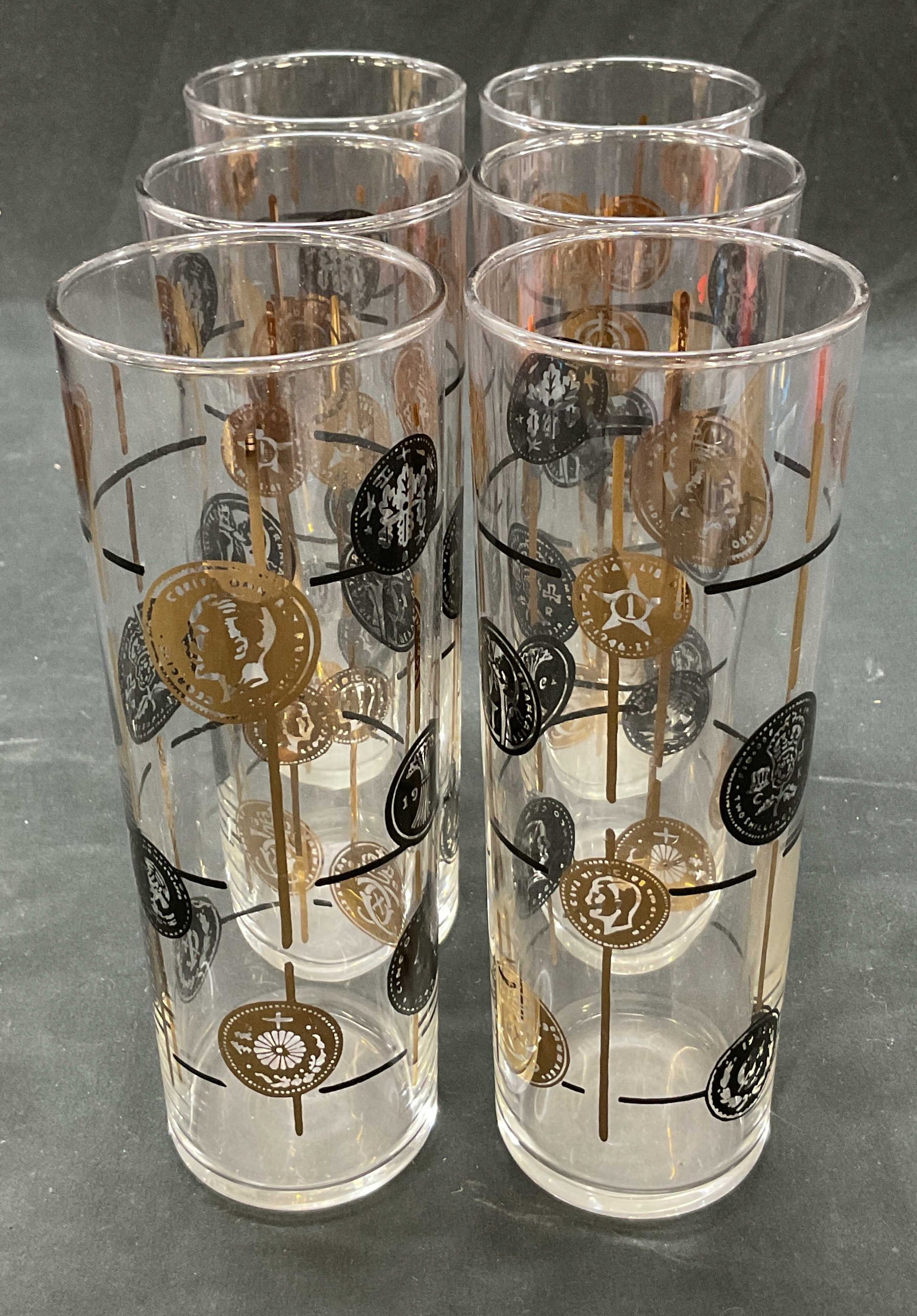 Set 6 Libbey Old World Coins Highball Glasses: Set of 6 Libbey Old World Coins highball glasses. Marked L on underside. Tall cylindrical glasses. Decorative pattern of black and gilt coin medallions arranged in a vertical grid. Variety of text and
