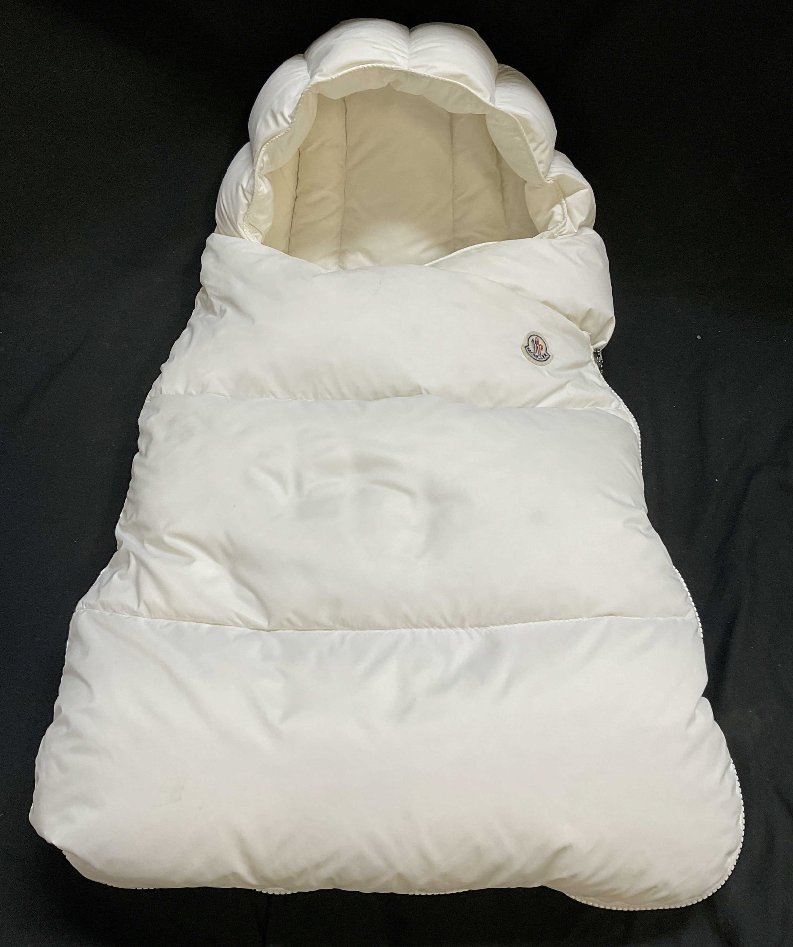 Moncler Infants Down Puffer Baby Nest ROMANIA: 2011 Moncler Infants Down Filled White Puffer Baby Nest. Made in Romania. Quilted Design with Brands Logo Patch. Full Length Zip Fastening. Some Staining. Measures app 13.5in Chest x 24.5in L. Moncler