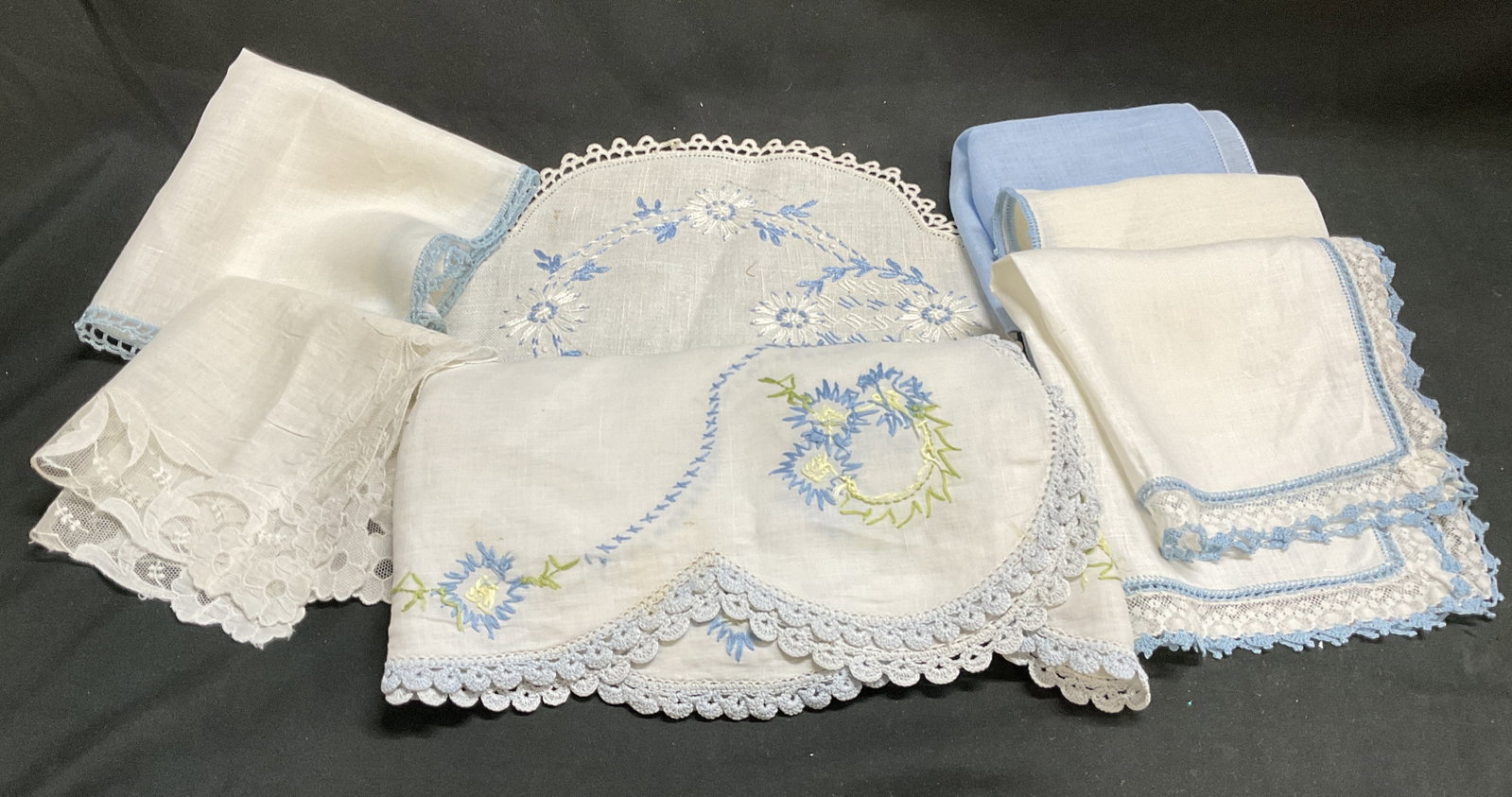 Lt7 VTG Blue & White Floral Lace Linens: 7 Vintage Blue and White Floral Lace Linens. Blue Floral Embroidery and Lacy Edges. Includes A Doily, 5 Tea Napkins, and a Small Table Runner. Staining and Holes Present. Largest Measures app 42.5in L