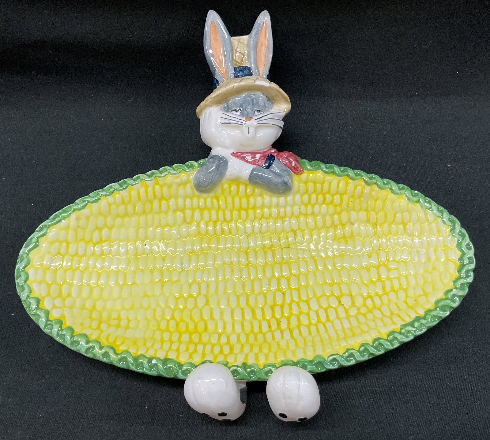 Vtg. 1995 Looney Tunes Buggs Bunny Corn Cob Dish.: vintage. 1995 Looney Tunes Buggs Bunny Corn Cob Dish. Buggs Bunny wearing sculpted straw farmers hat and red neck kerchief. White paws molded over rim. Feet peek out beneath bottom edge. Serving surfa