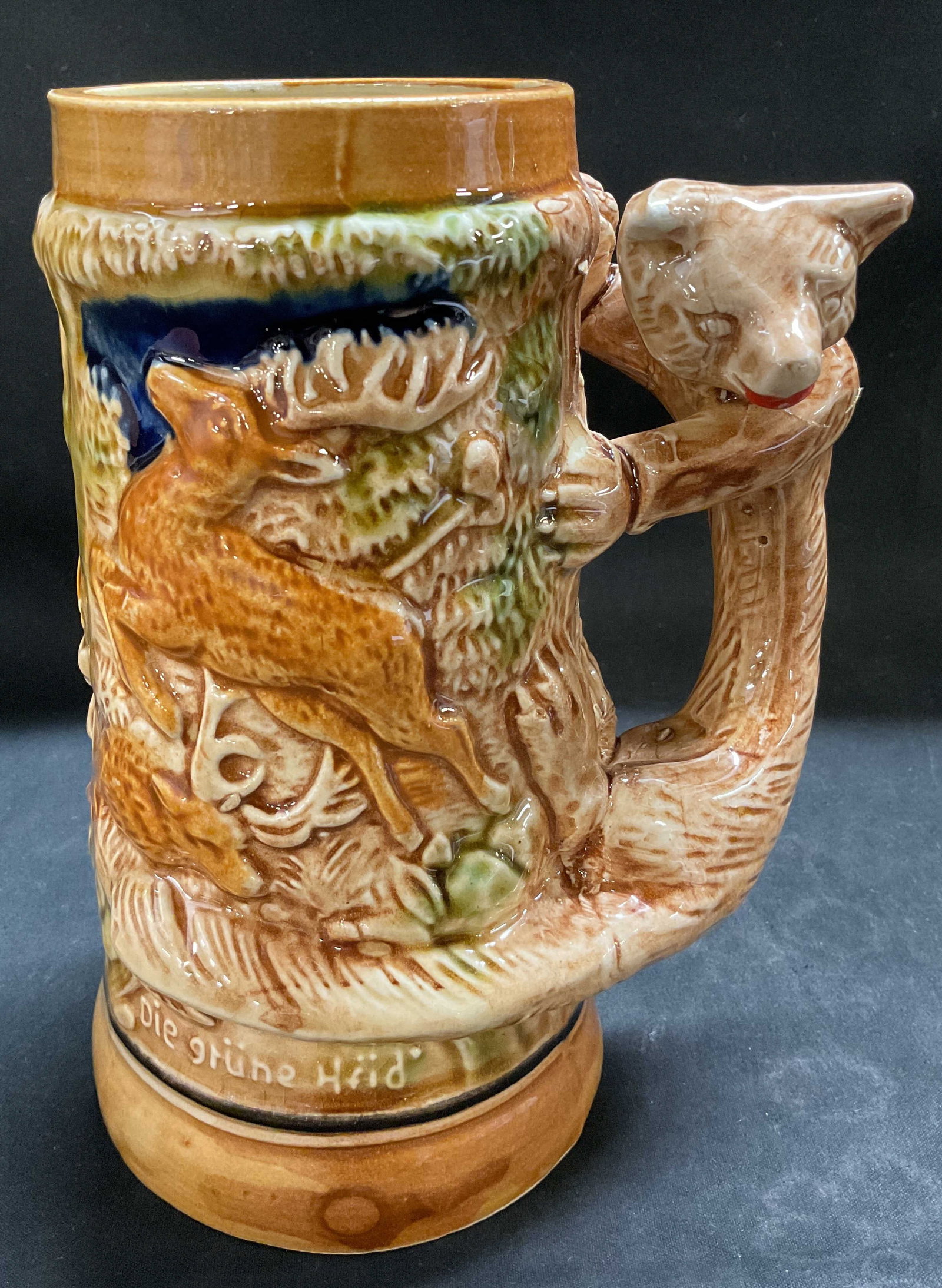 Vtg Woodland Ceramic Beer Stein JAPAN: Vintage ceramic beer stein featuring a relief woodland scene. Bear shaped handle. German phrase reads, Die Gr?ne Heid. Signed & marked on underside. Reads, JAPAN. Surface wear consistent to age, use &