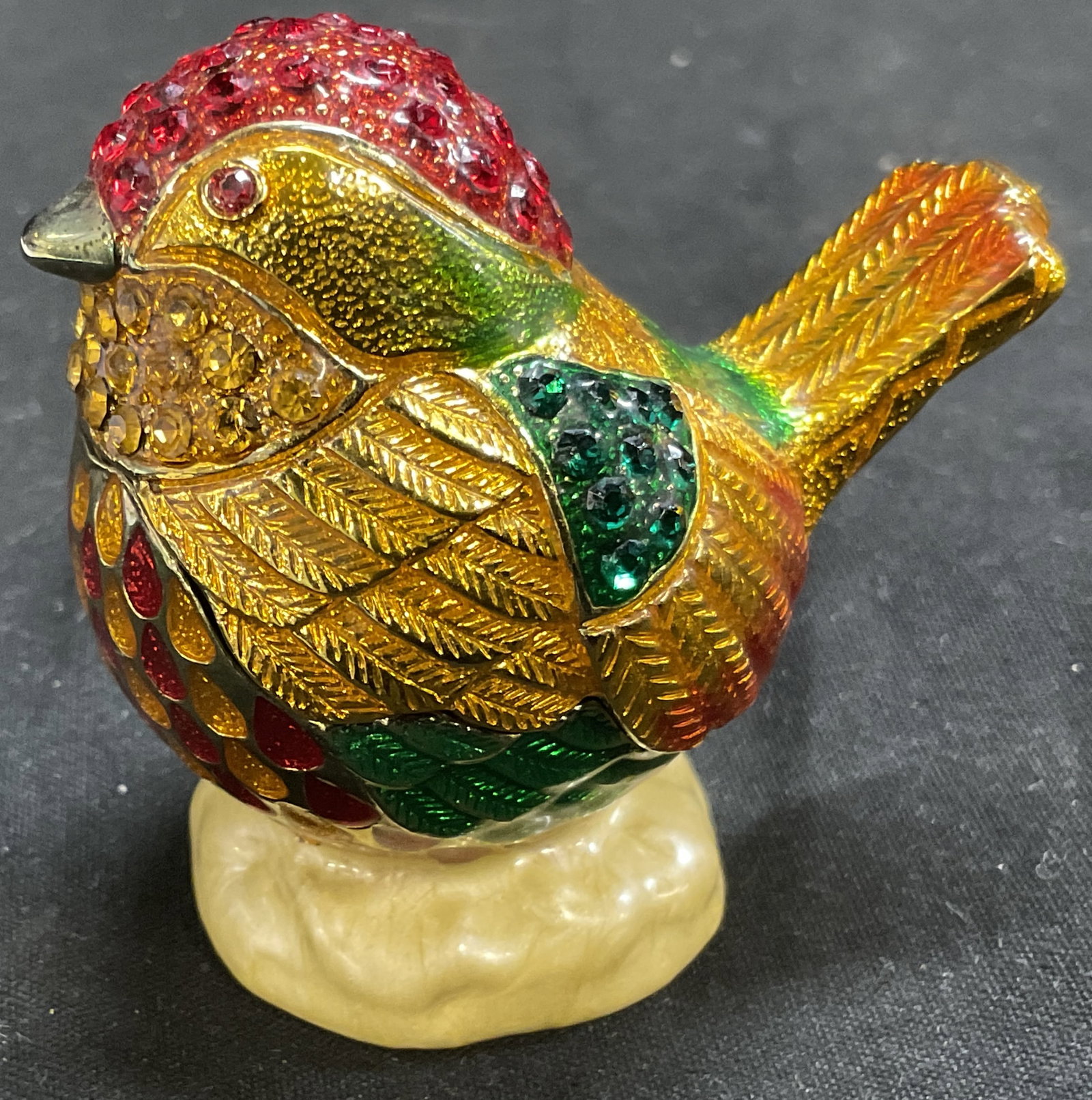 Ruccini Swarv Crystal & Pewter Bird Trinket Box: Ruccini Bejeweled Metal Bird-Shaped Trinket Box. Gold-Toned Pewter. Colorful Swarovski Crystals and Enamel. Swirled Yellow Enamel Interior. Magnetic Clasp. Condition Consistent With Exposure. Measures