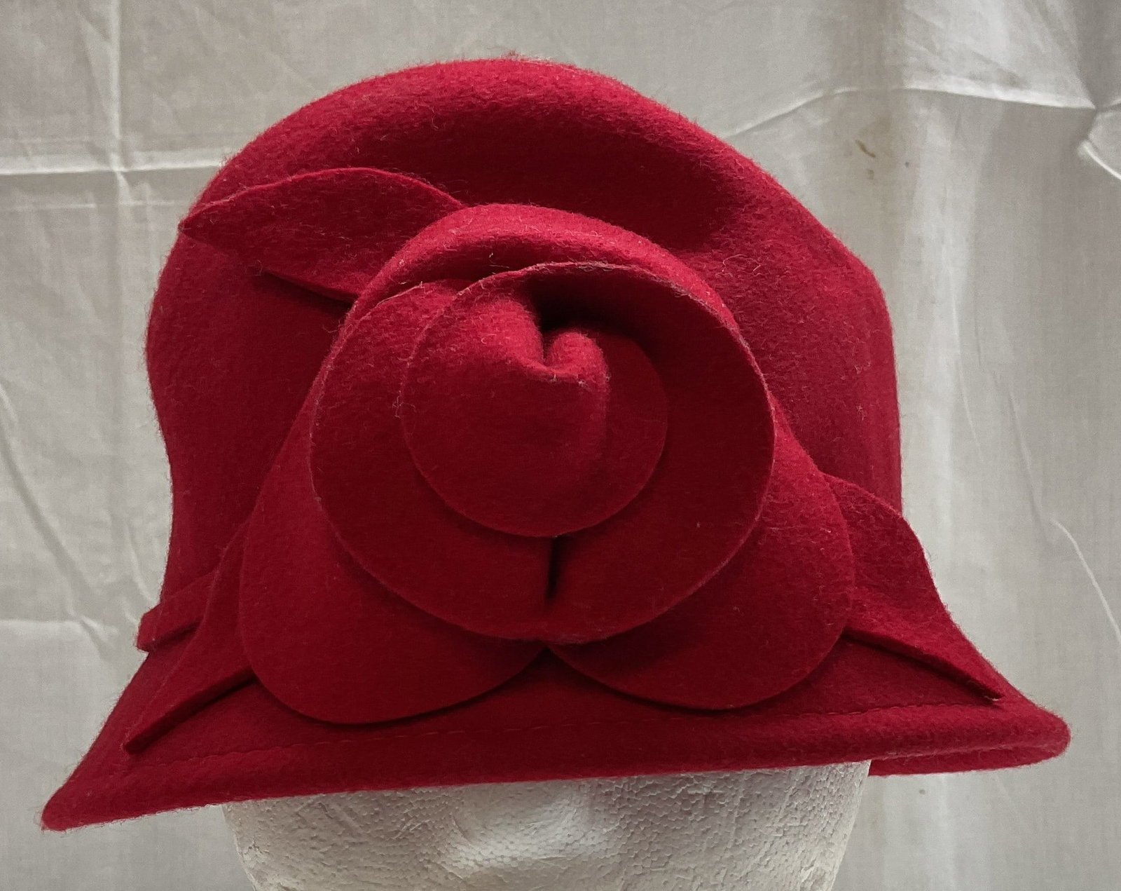 Crafts & Barrow Wool Floral Hat: 100% wool. Hat features a floral motif in center. Red toned. Surface wear consistent to age, use & exposure. Measurements: length 10.5in x width 9.2in. Crafts & barrow wool hat, wool hat, wearables,