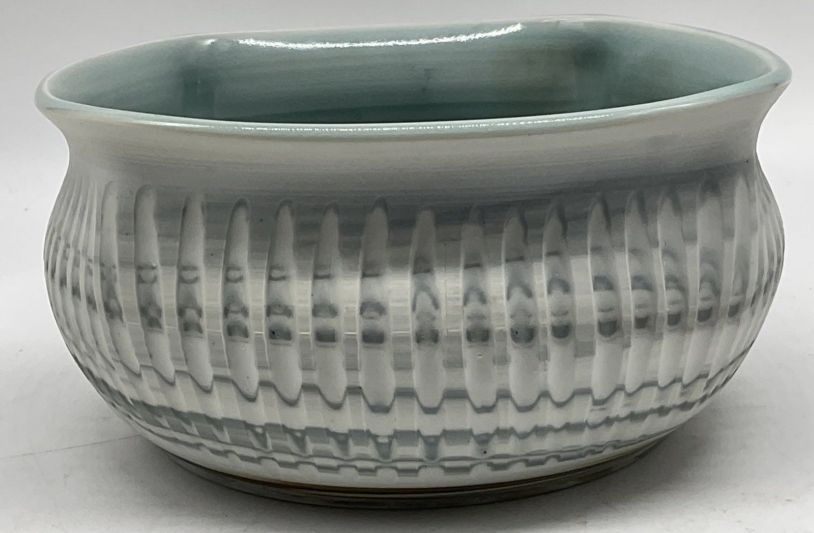 SGND Indented Squared Shape Blue Pottery Bowl: Signed Multi-Toned Blue and White Pottery Bowl with Squared and Fluted Shape. Embossed Indentations. Light Blue Glaze Interior. Signature Reads Illegibly. #2048. Measures approx 4 in height, 8 in
