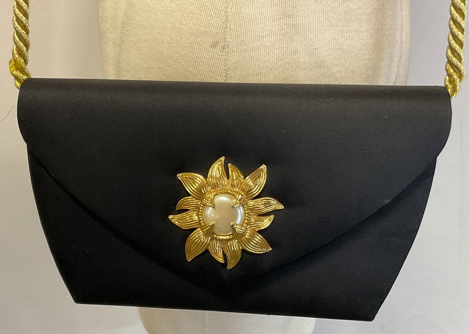 Victor Costa Black Silk Evening Purse Hong Kong: Victor Costa black silk evening purse. Made in Hong Kong. Gold toned braided strap. Button closure. Decorative gold toned sun accent. Compartments on interior. Measures approx 5 x 9.5 inches. Surface