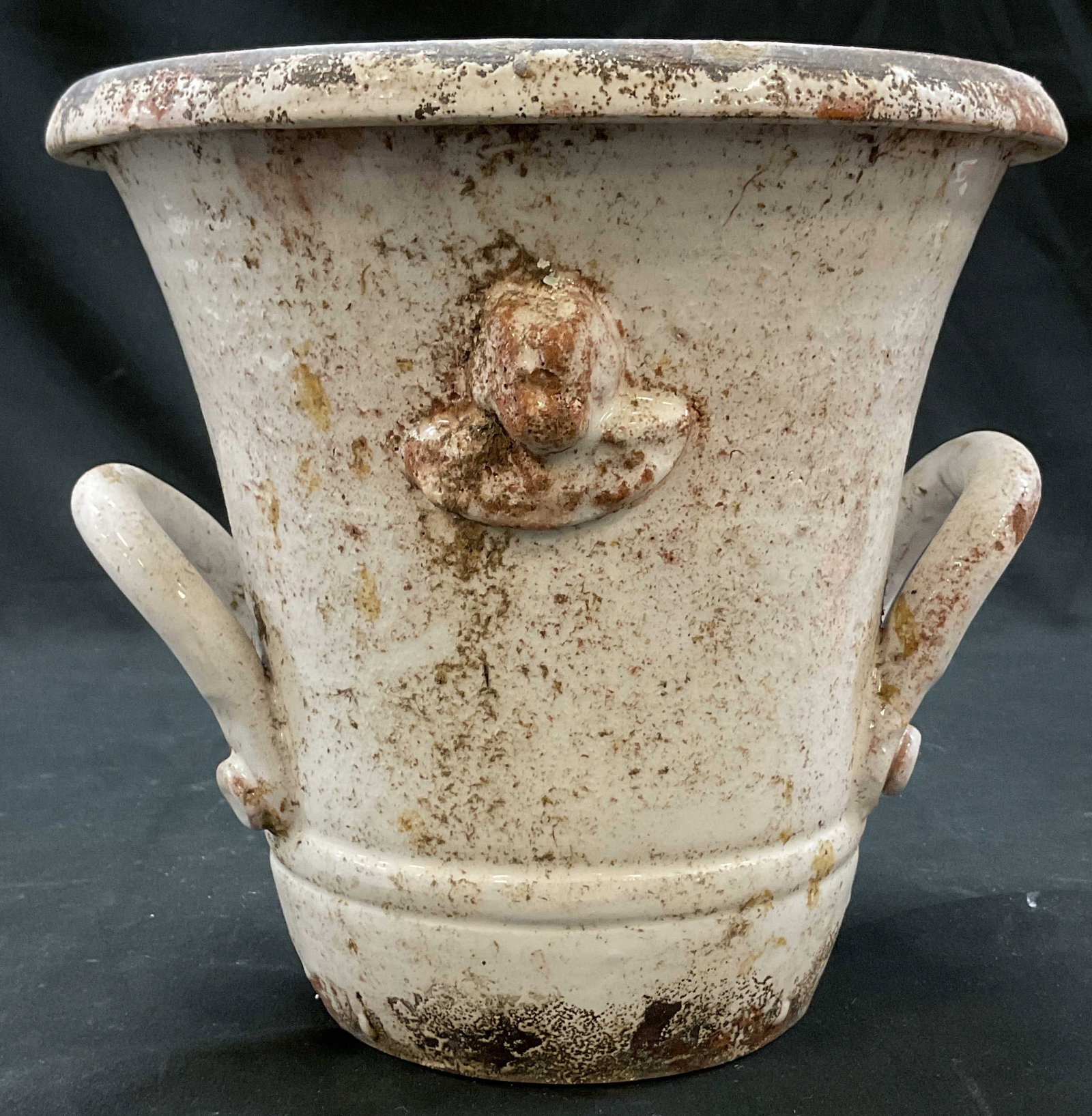 Vtg Italian Style Terracotta Cherub Planter: Vintage Italian Style Terracotta Cherub Planter. Distressed aged glaze urn with handles. Raised relief mold of winged cherub head as centerpiece. Two thick looped side handles. Wide flared rim. Measur