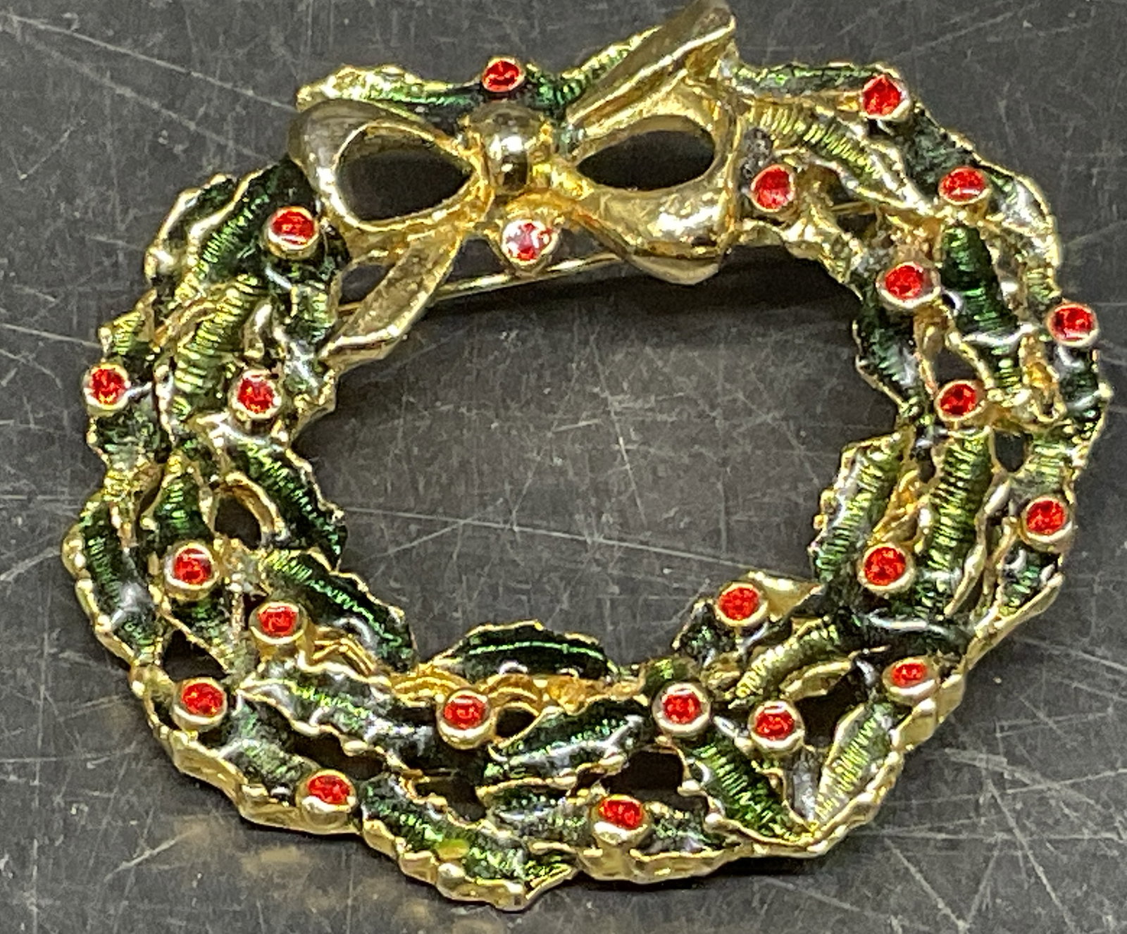 VINTAGE Gold-Toned Christmas Wreath Brooch: Vintage Gold-Toned Christmas Wreath Brooch. Green Enamel Holly Leaves. Red Rhinestone Berries. Decorative Bow. Some Corrosion on Back. Measures app 1.5in Diam. Vintage Brooches, Gold-Toned, Christmas