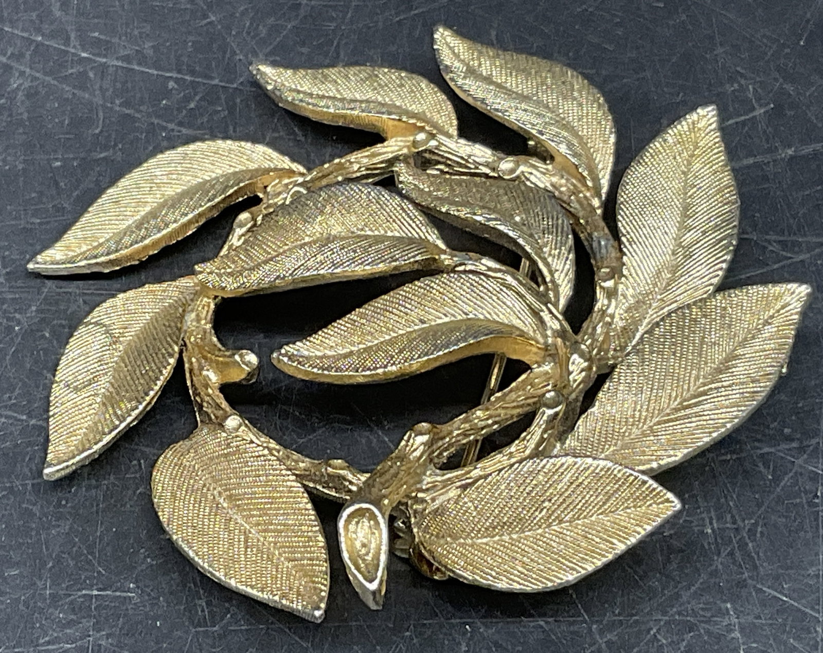 VTG Lisner Gold-Toned Wreath of Leaves Brooch: Vintage Lisner Gold-Toned Wreath of Leaves Brooch. Textured Foliage on Detailed Stem. Some Wear to Plating. Measures app 2in Diam. Vintage Brooches, Lisner, Gold-Toned, Wreath, Leaves, Foliage, Pins,