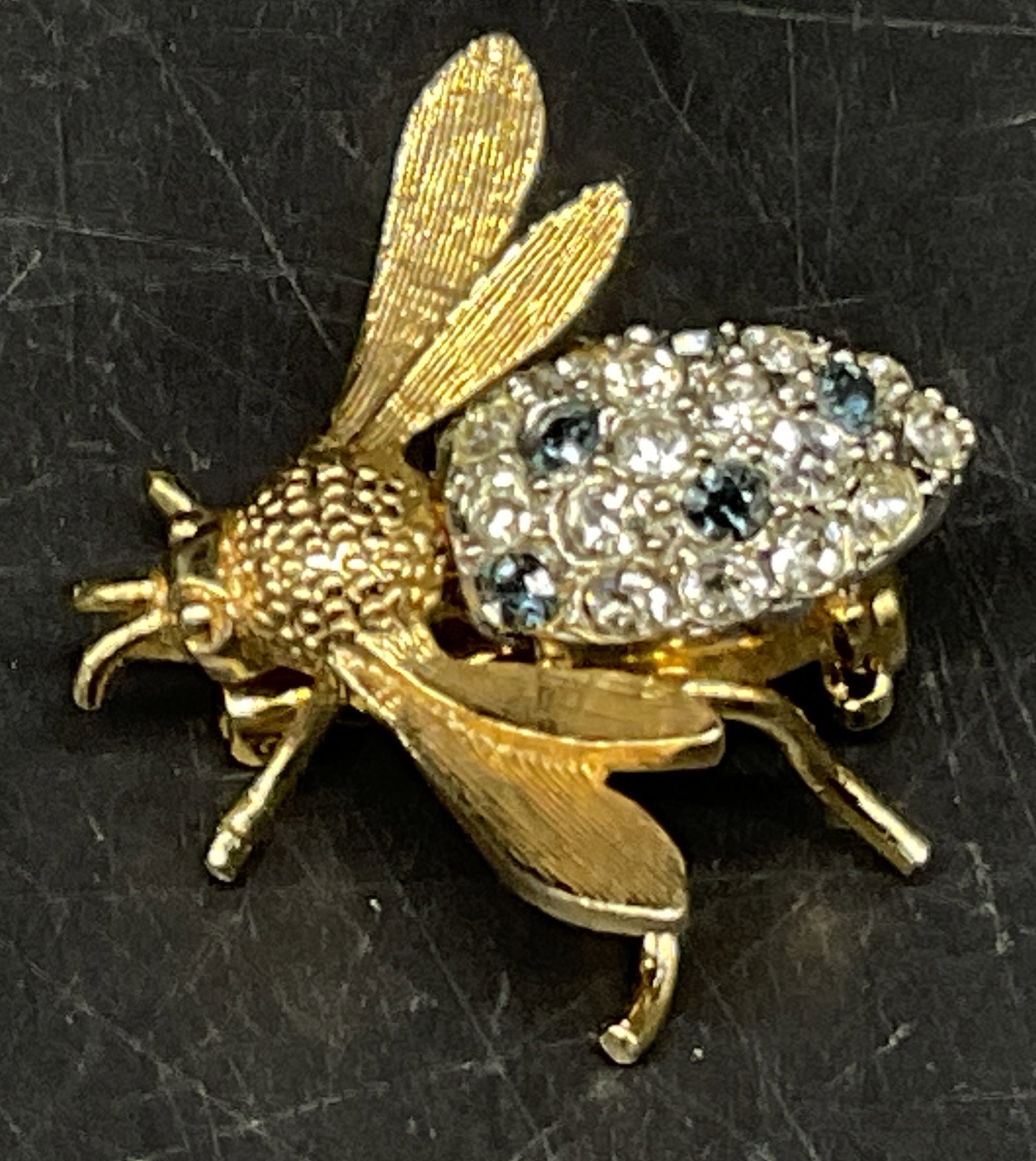VINTAGE Rhinestone Bumblebee Brooch: Vintage Gold-Toned Bumblebee Brooch. Blue and Clear Rhinestone-Encrusted Abdomen. Textured Wings. No Visible Markings or Brand. Condition Consistent With Exposure. Measures app 1in H. Vintage