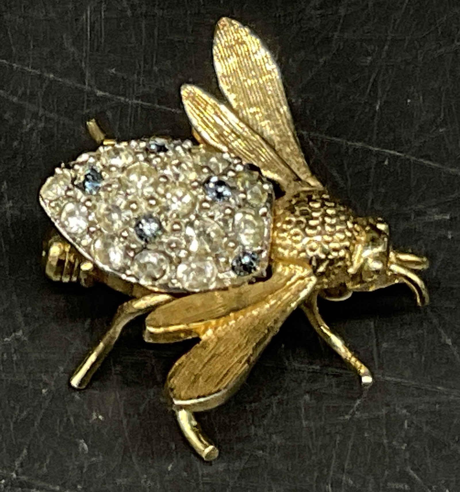 VTG Rhinestone Bumblebee Brooch: Vintage Gold-Toned Bumblebee Brooch. Blue and Clear Rhinestone-Encrusted Abdomen. Textured Wings. No Visible Markings or Brand. Condition Consistent With Exposure. Measures app 1in H. Vintage