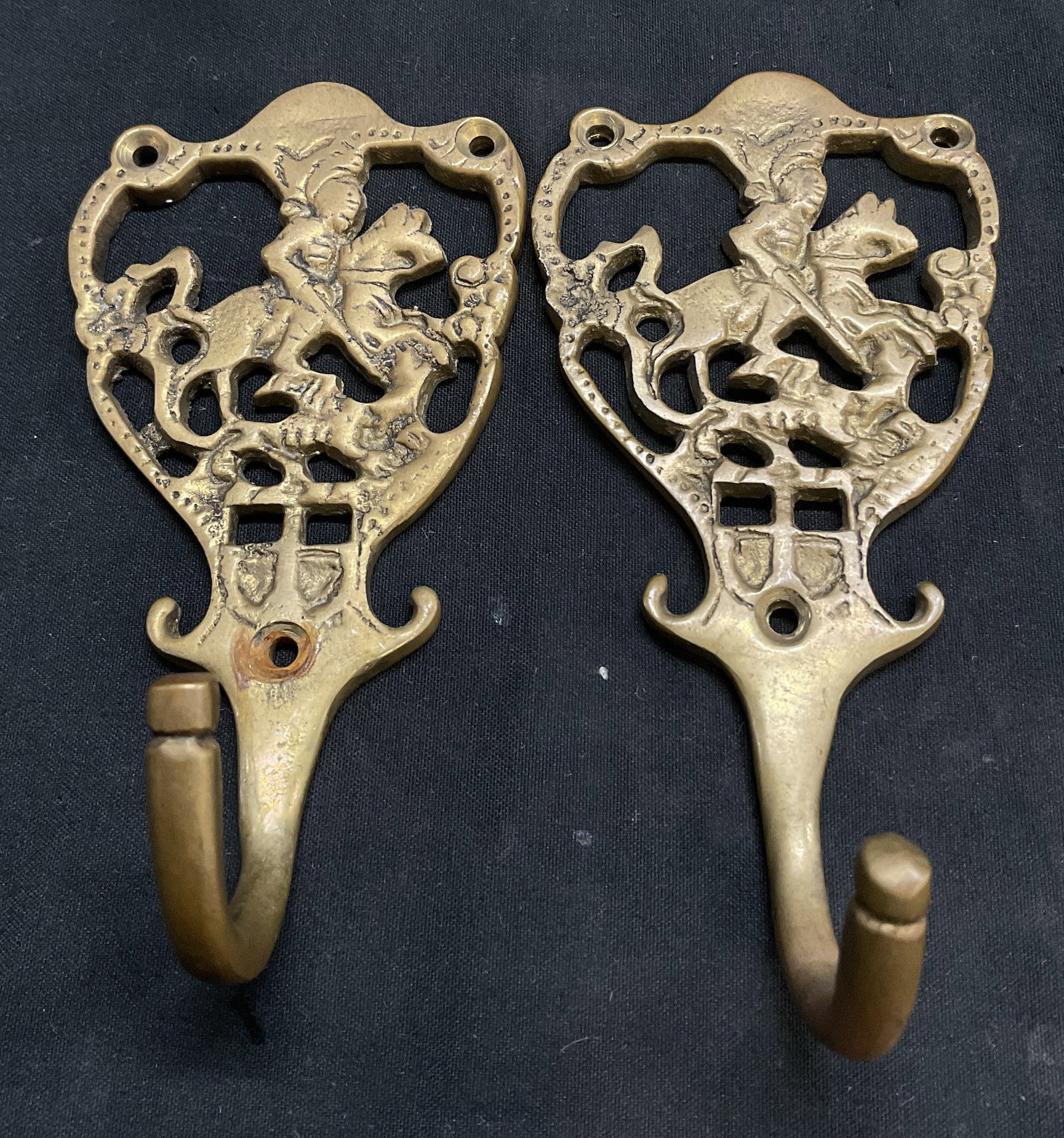 VTG Cast Brass Medieval Knight on Horse Wall Hooks: 2 Vintage Cast Brass Intricate Openwork Wall Hooks. Depicts a Medieval Knight on a Horse. Aging to Metal Present. Measures app 5in H x 2.5in L. Vintage Wall Hooks, Brass, Openwork, Knights, Horses, Me