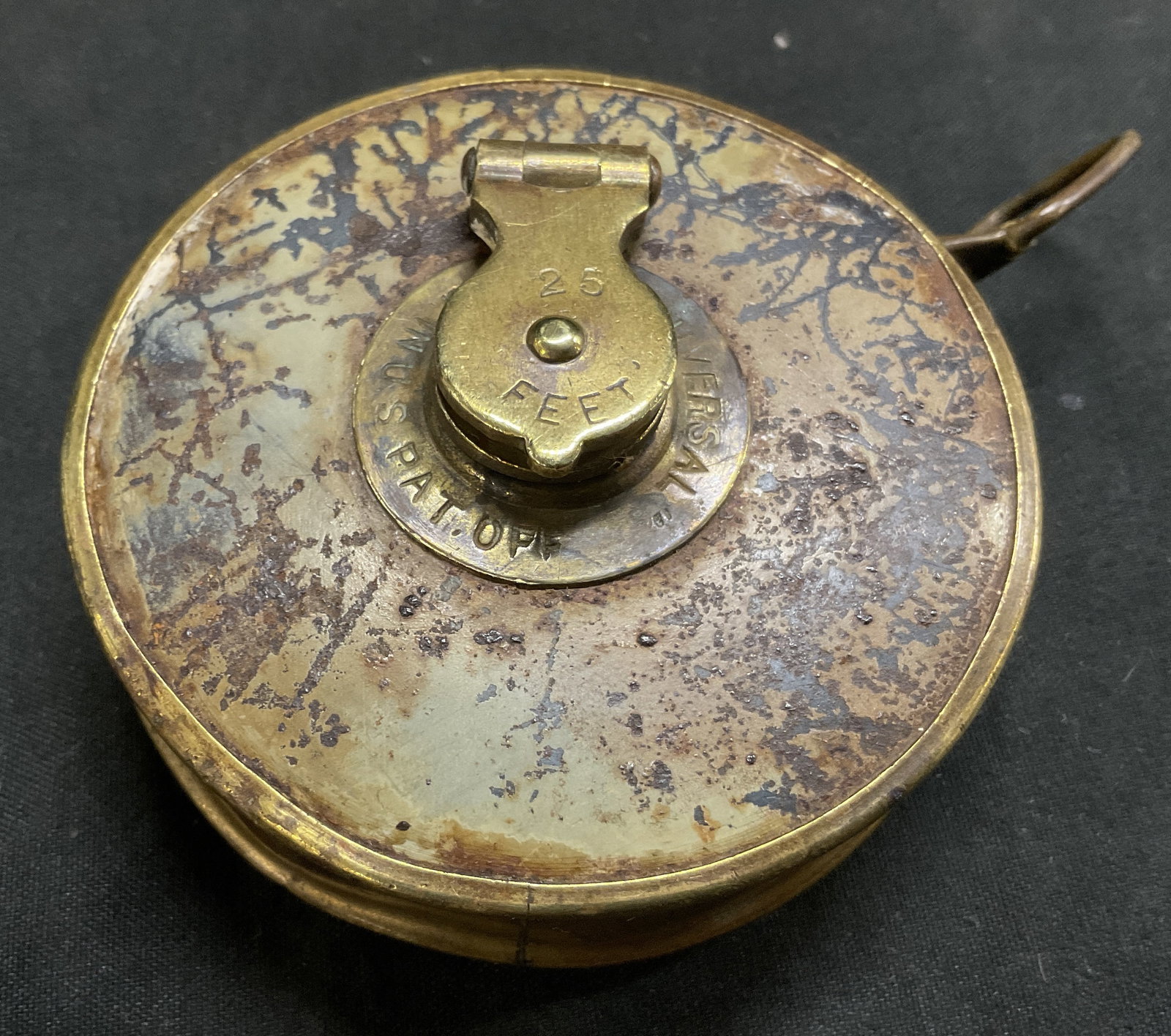 VTG 25-Ft Cloth Measuring Tape Brass Case U.S.: Vintage 25-Foot Cloth Measuring Tape. Brass Case with Leather Inserts. Winding Crank Mechanism in Center. Registered in United States. Crackling to Leather and Corrosion to Metal Present. Fading to