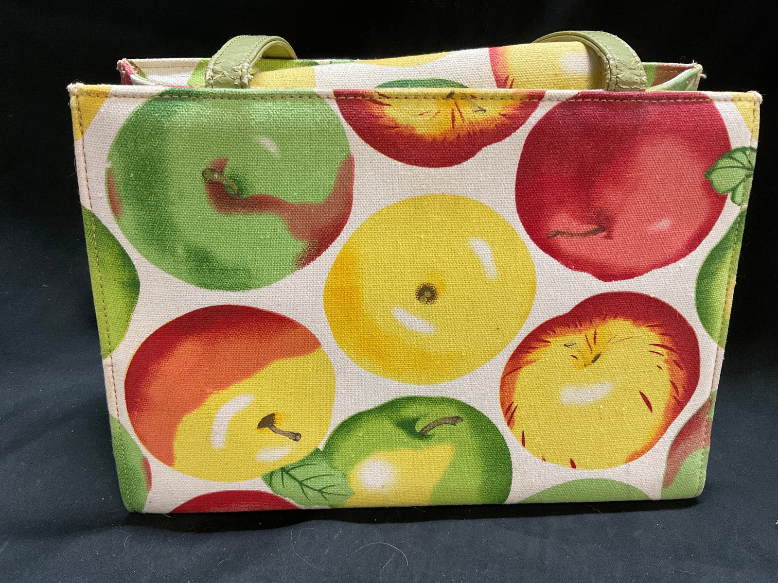 VINTAGE Apples Canvas Tote Handbag: Vintage Tote Handbag. Various Types of Green, Yellow, and Red Apples on Beige Canvas Background. Green Leather-Style Handles. Multi-Colored Striped Canvas Interior. Fraying to Handles and Staining