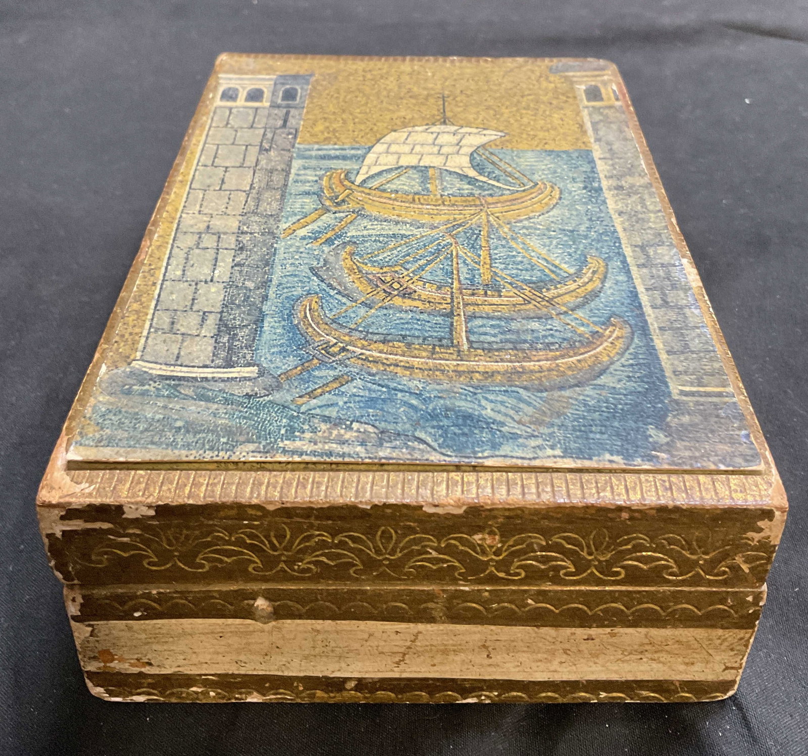 VTG Florentine Decoupage Wooden Box ITALY: Vintage Florentine Wooden Box. Byzantine Ships in Water by Naval Port Decoupage Design on Lid. Painted Gilt Sides. Made in Italy. Chipping, Paint Loss, and Pen Marks Present. Measures app 2in H x