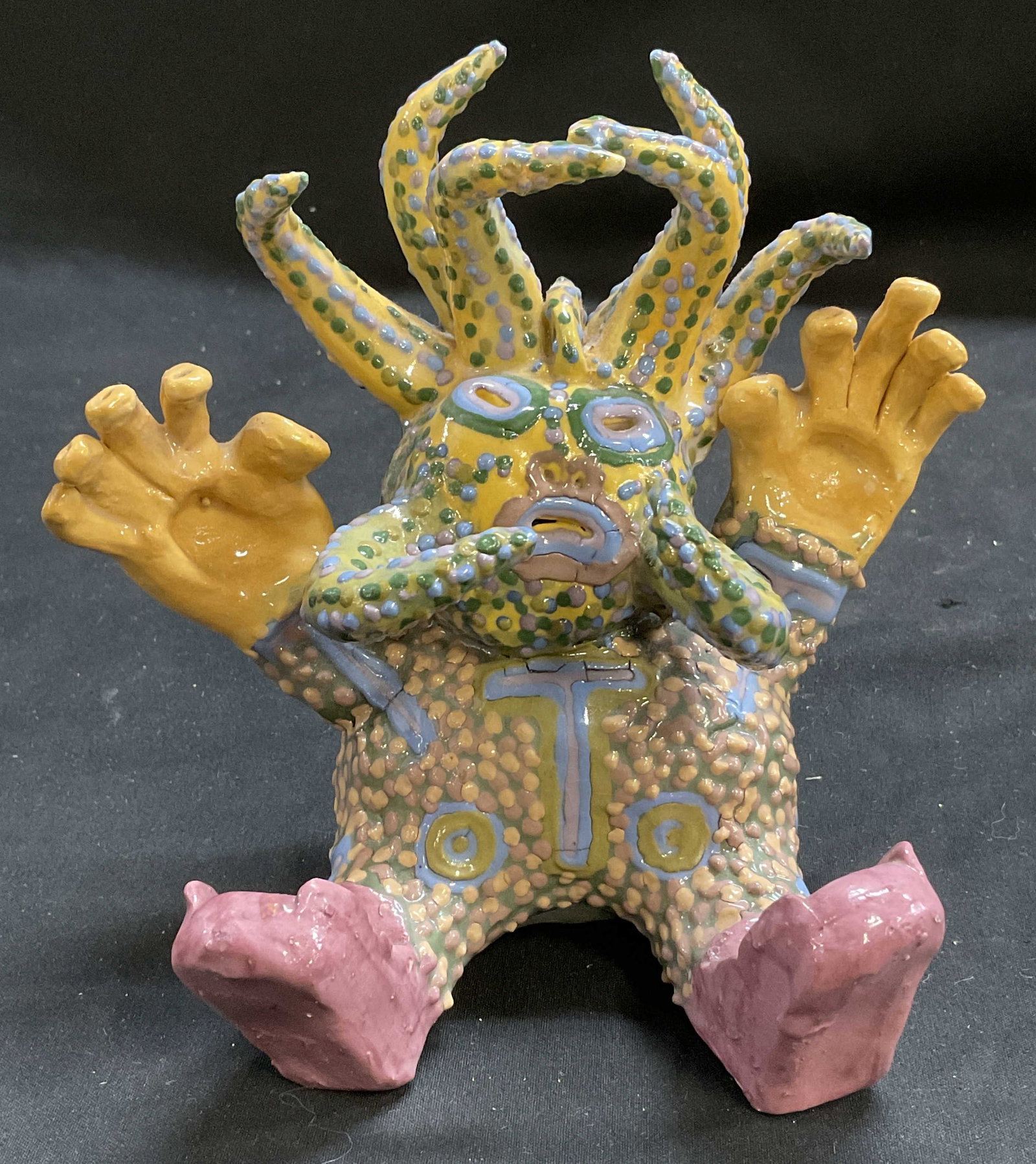 Handmade Colorful Glazed Ceramic Monster Figurine: Handmade Colorful Glazed Ceramic Spotted Monster Figurine. Tentacles Attached to Head and Face. Large Yellow Hands. Seated Position. Condition Consistent With Exposure. Measures app 5.5in H x 6in L.