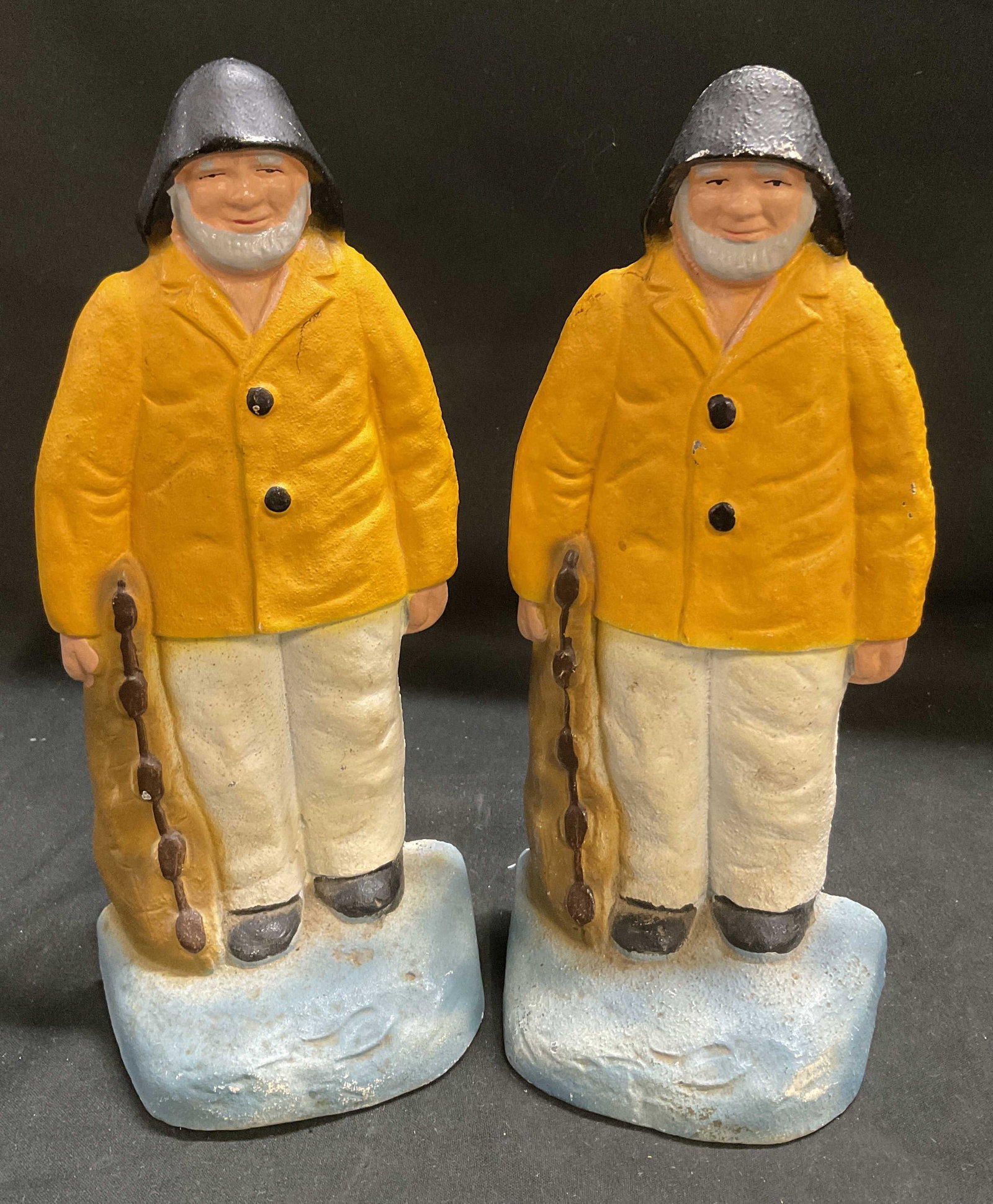 VINTAGE Cast Iron Old Salt Fisherman Bookends: Vintage Painted Cast Iron Old Salt Fisherman Bookends. Old Bearded Men in Yellow Raincoats and Black Cape Ann Sou wester Hats Holding Fishing Nets. Paint Loss Present. Measures app 8.25in H x 3in W.