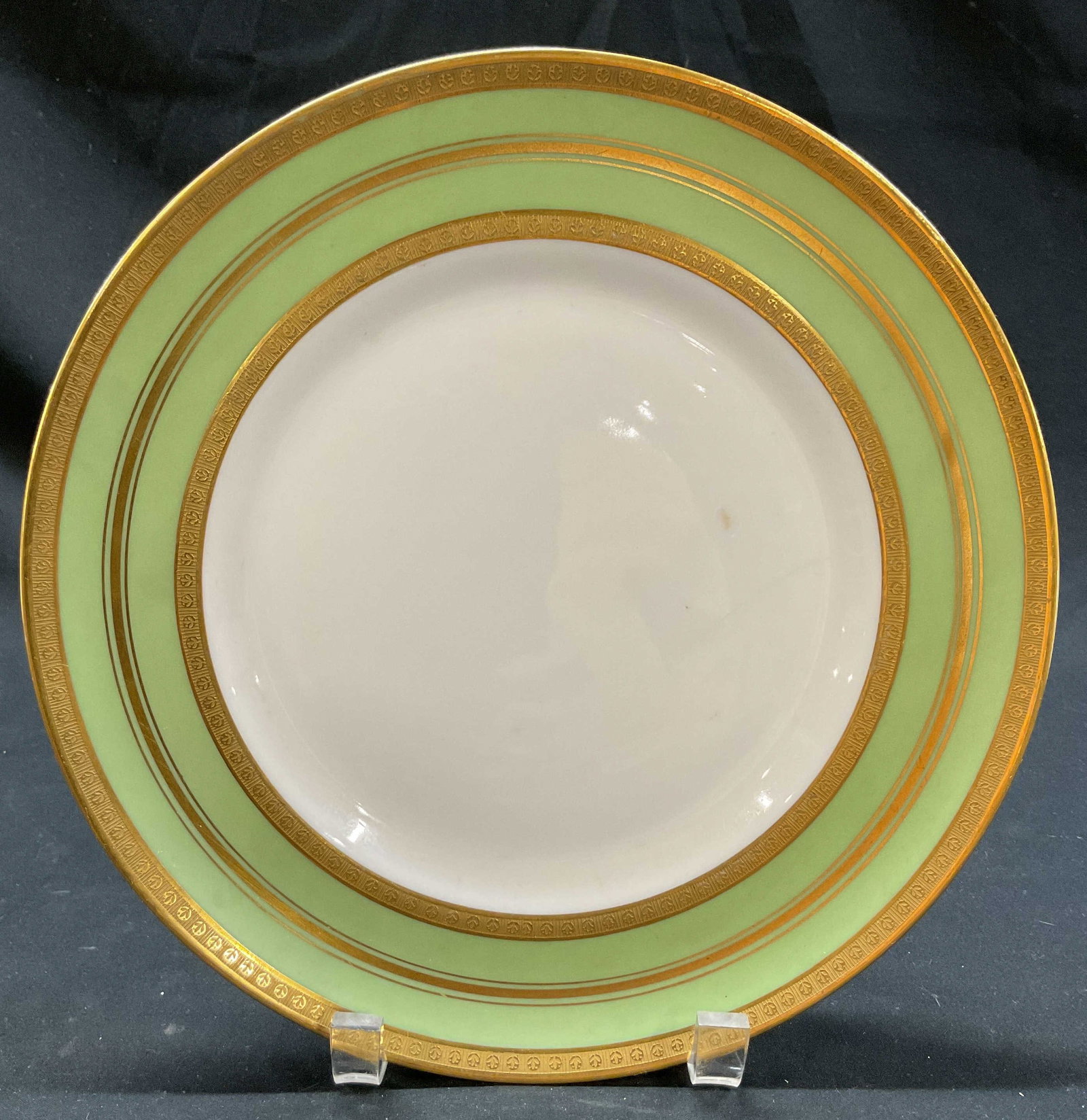 Porcelaine Limousine Limoges Plate France: Porcelaine Limousine Limoges porcelain plate. Marked on underside, made in France. Round plate with gilt rim. Green and gilt design. Embossed floral pattern. Measures approx 10 inches in diameter.