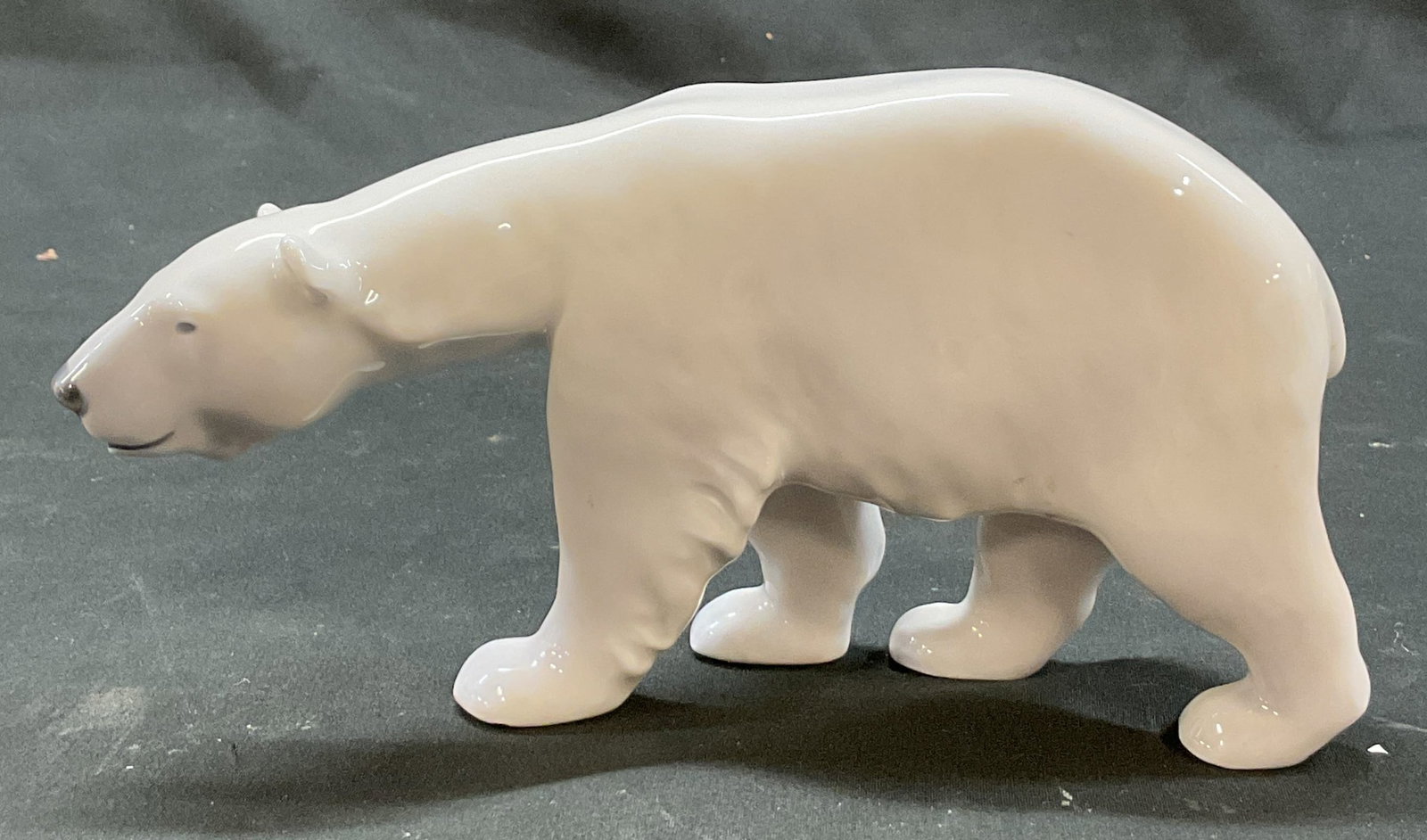 Royal Copenhagen Polar Bear Figure Denmark: Royal Copenhagen porcelain polar bear figure. Marked Denmark on surface. Polar bear figure in walking pose. Measures approx 1.5 x 8 x 4 inches. Surface wear consistent with exposure. Polar bear