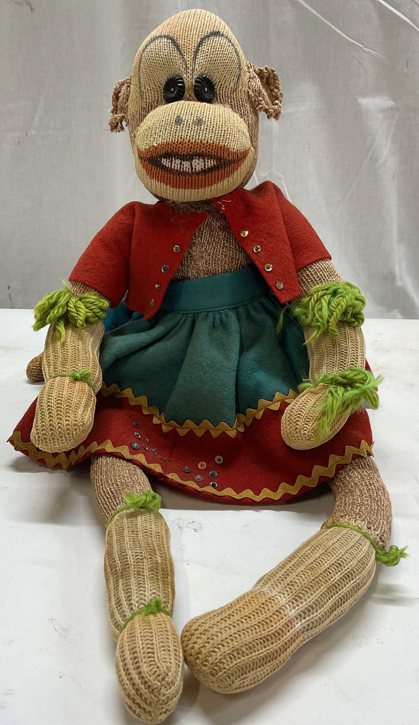 Vtg Handmade Sock Monkey Doll: Vintage Handmade Sock Monkey Doll. Classic Heather brown knit socks with red and white stitched mouth, custom outfit, red felt jacket with mini sequins, teal and red layered skirt with yellow