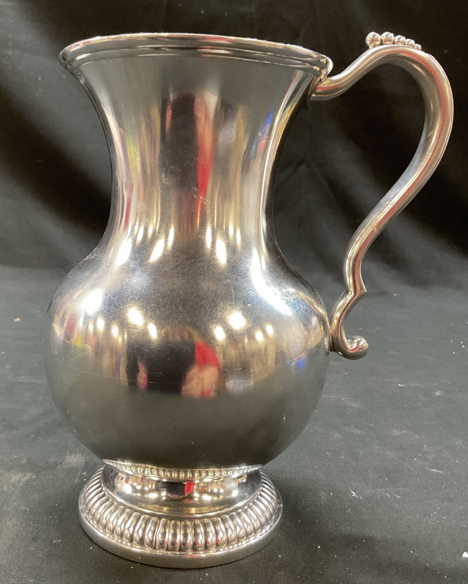 Pierre Deux Footed Pewter Pitcher: Pierre Deux footed pewter pitcher. Marked on underside. Footed base with ribbed surface. Bulbous body and slender neck. Curved handle and spout. Measures ht approx 8 inches diam approx 4.5 inches.