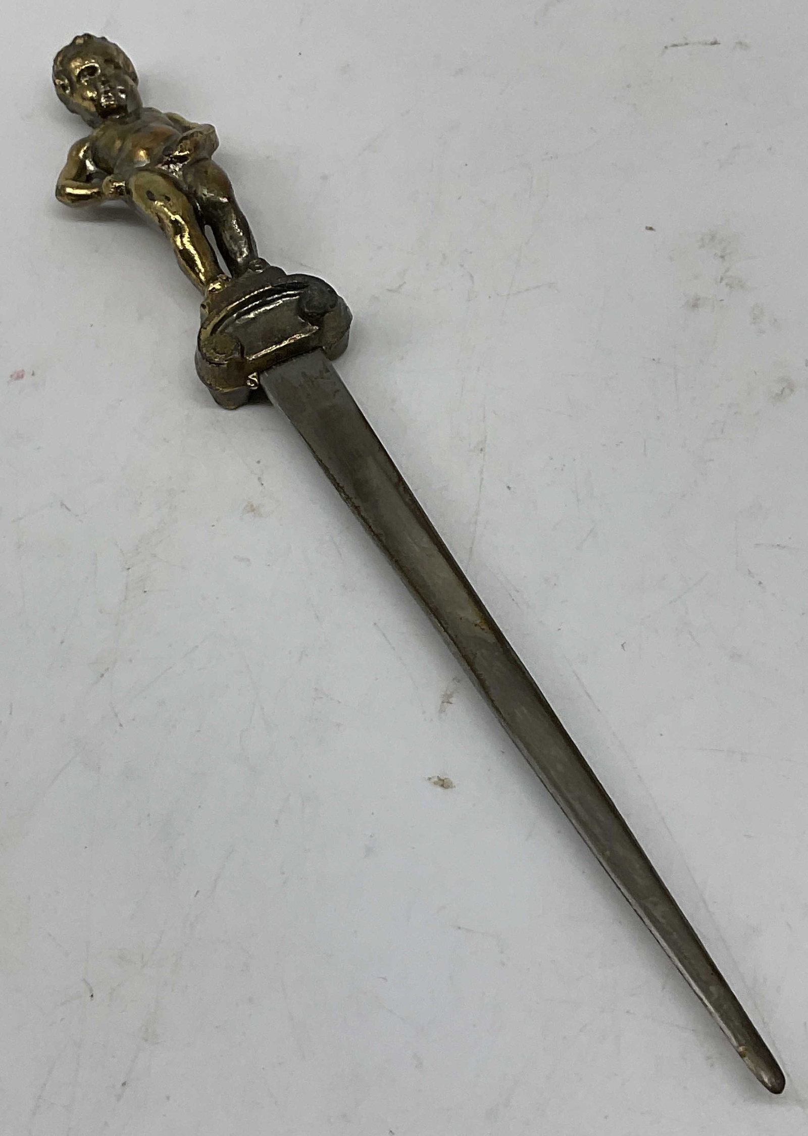 VTG Brass Mannekin Pis Letter Op BELG: Vintage Brass Mannekin Pis Letter Opener. Silver-Toned Blade. Modeled After the Famous Statue in Brussels, Belgium. Made in Belgium. Some Wear to Plating. Measures app 7.25in H x 1in W. Vintage Letter