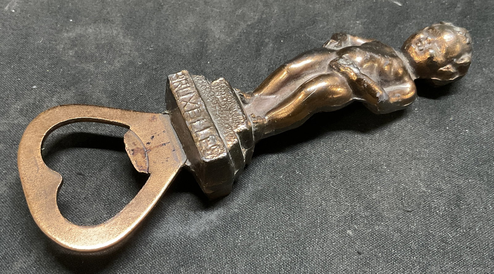 VTG Bronze Finish Mannekin Pis Bottle Opener BELG: Vintage Mannekin Pis Letter Opener. Pot Metal with Bronze Finish. Base Reads Bruxelles. Modeled After the Famous Statue in Brussels, Belgium. Made in Belgium. Some Wear to Paint. Measures app 7.25in