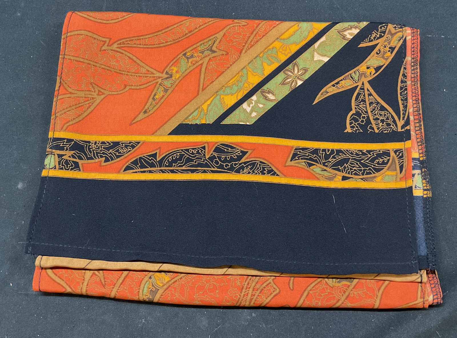 Vintage Multicolor Leaf & Floral Silk Scarf: Vintage multicolor leaf and floral silk scarf. Leaf and floral motifs. Orange, green, yellow, black, etc. Striped pattern. Measures approx 9 x 58 inches. Wear consistent with exposure. Scarf, wearable
