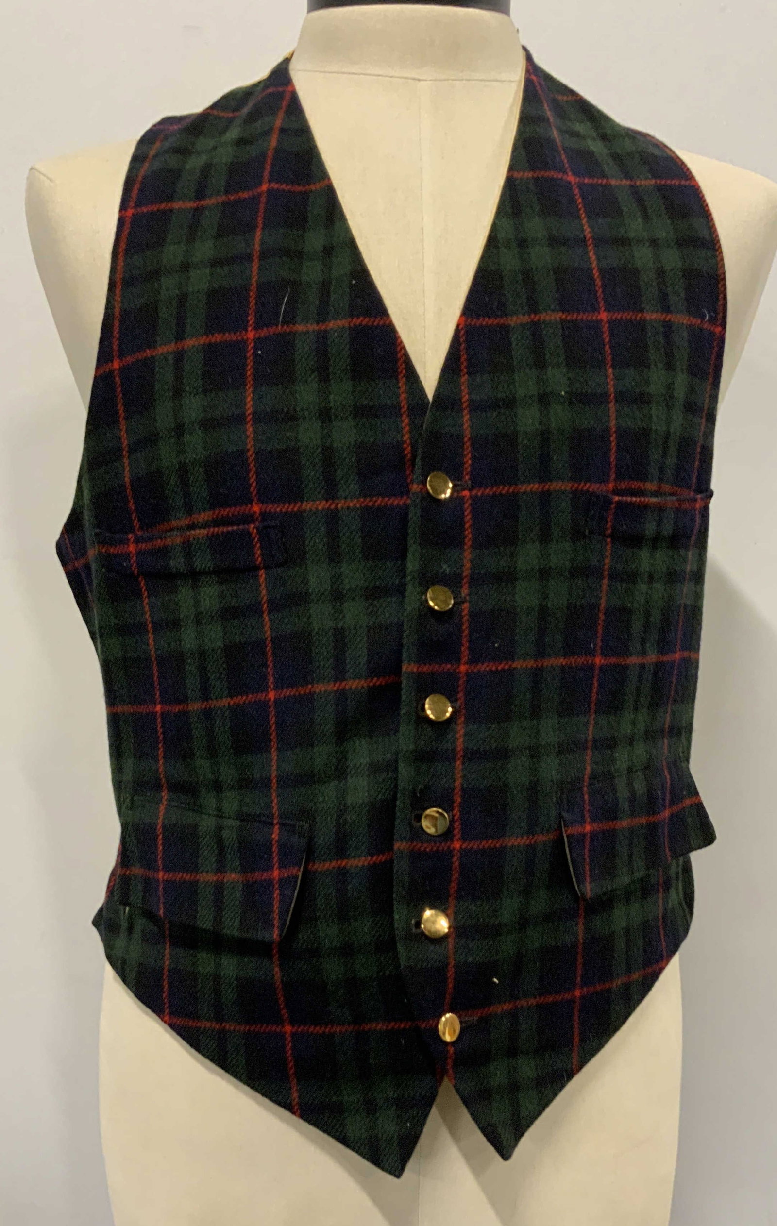J.Press all wool plaid vest.: J. Press all wool plaid vest. Made in England. No size listed ,measures app 19 in across and app23 in length. Buckle in the back to change size if needed. Green and red plaid on the front and gold col