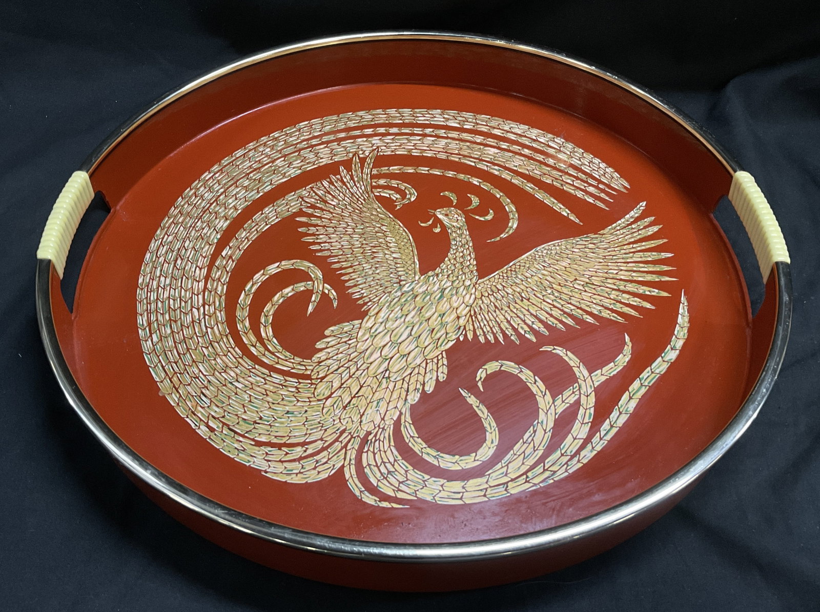 VTG Japanese Phoenix Design Metal Beverage Tray: Vintage Japanese Metal Beverage Tray. Painted Red Aluminum with Green, Beige, and Gold-Toned Phoenix Design. Cord Wrapped Handles. Measures app 15.75in Diam. Scrape Present. Vintage Beverage Tray,
